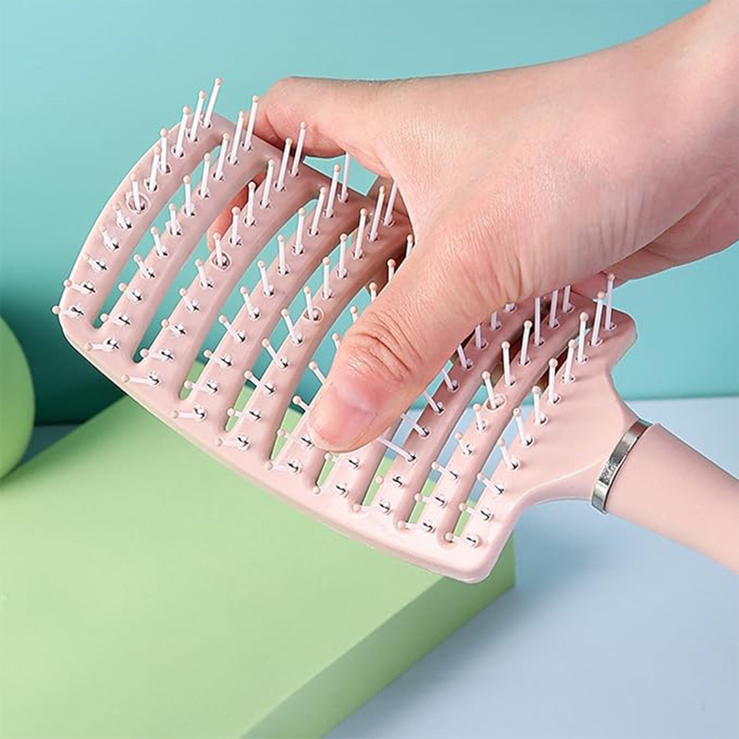 Massage hair comb held by hand showing anti-slip handle for comfortable styling