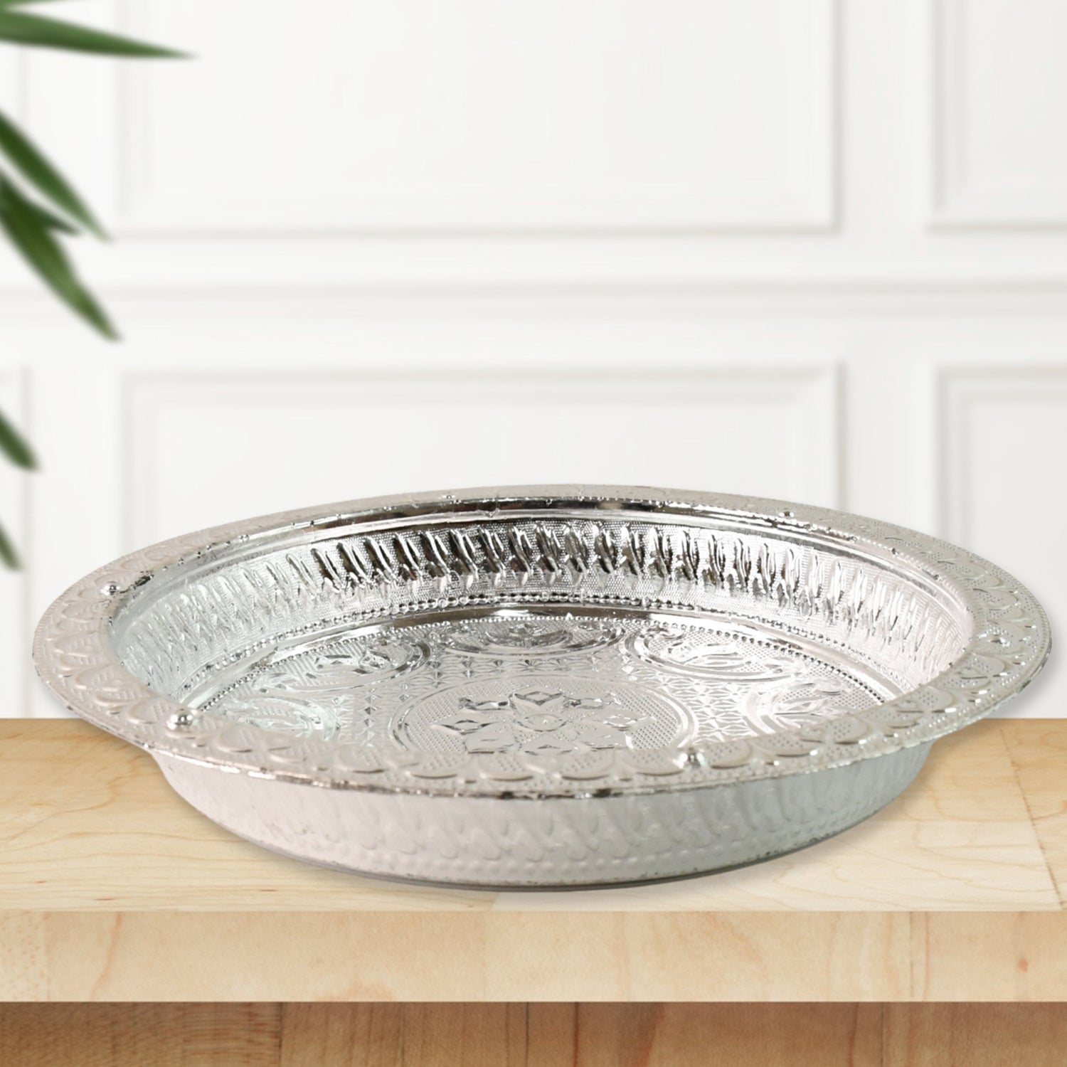Decorative plastic pooja thali featuring silver finish and floral embossing