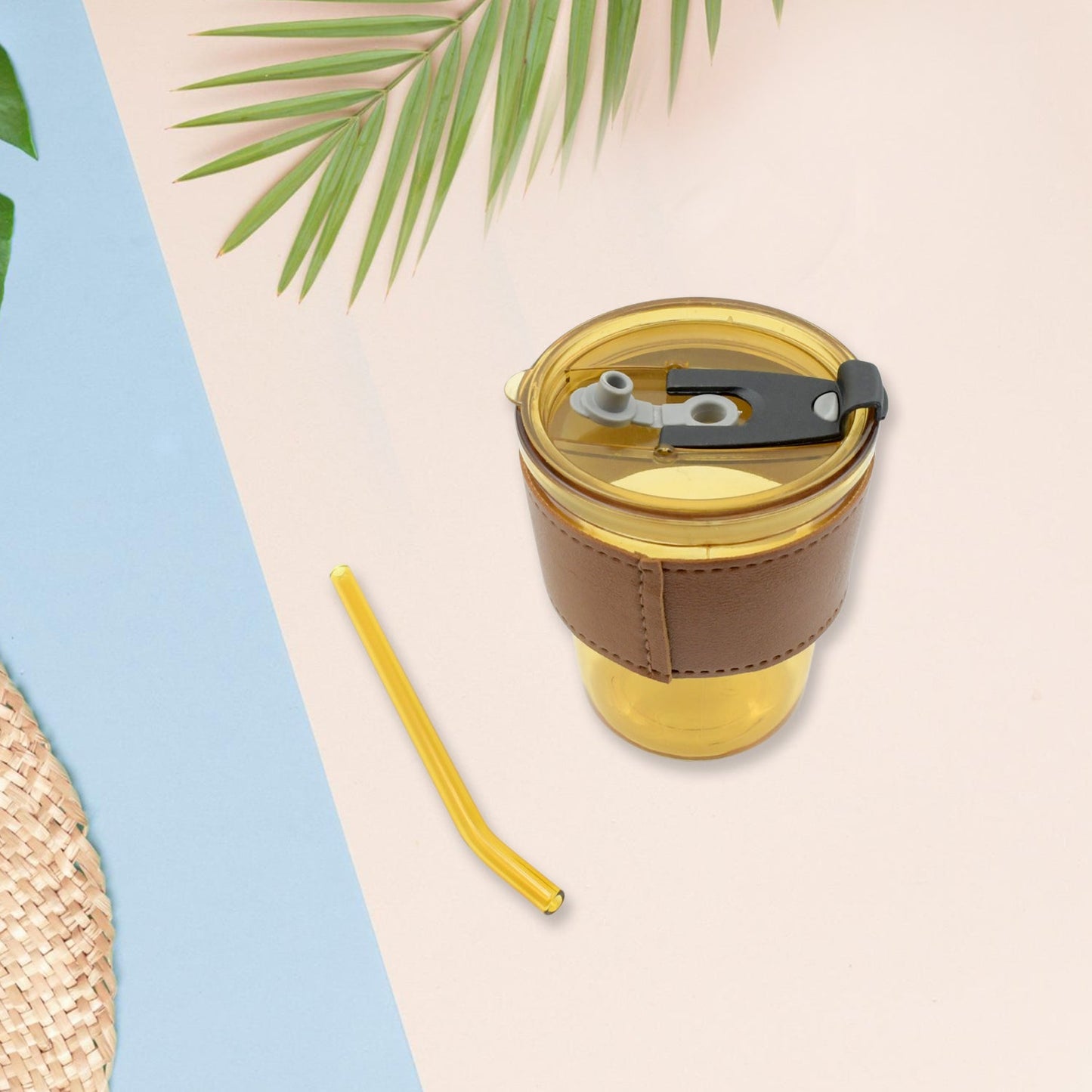 Convenient clear glass mug with a protective sleeve, straw, and leakproof lid.