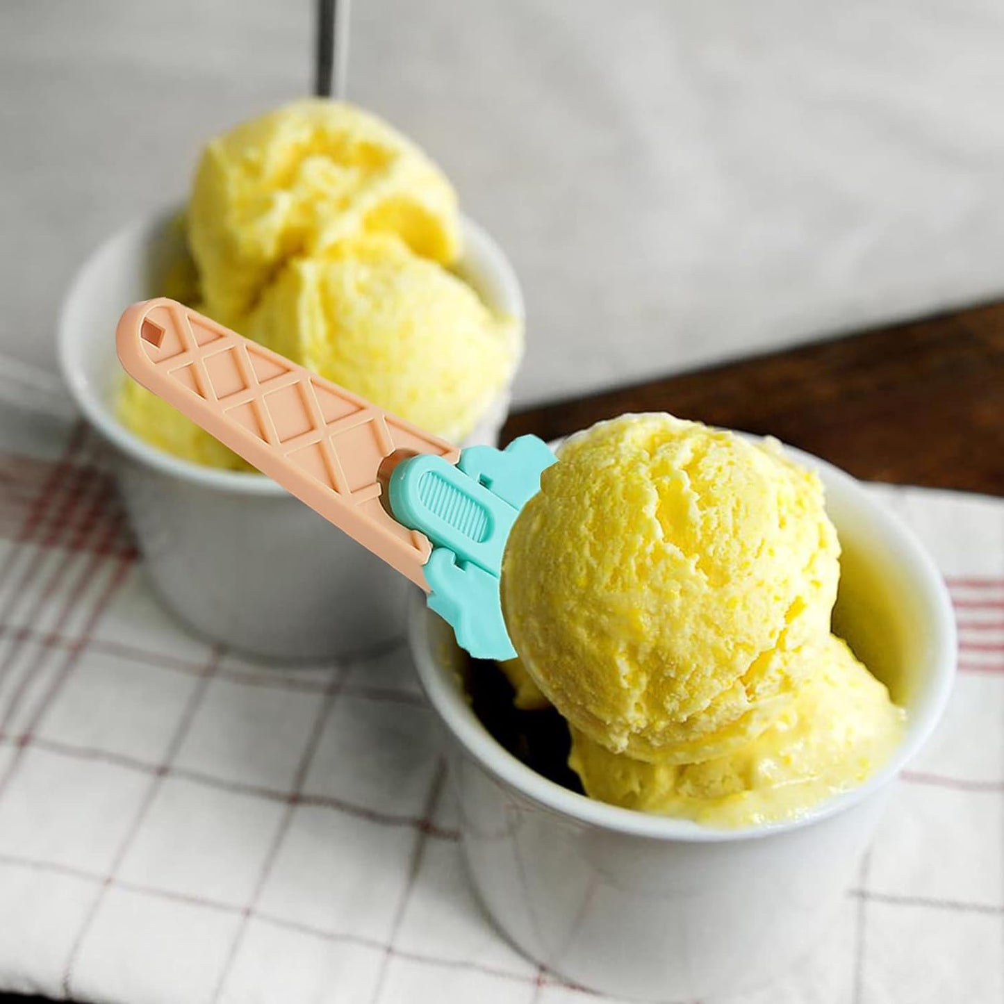 Ergonomic plastic ice cream scoop in green, showing the easy-release trigger mechanism.
