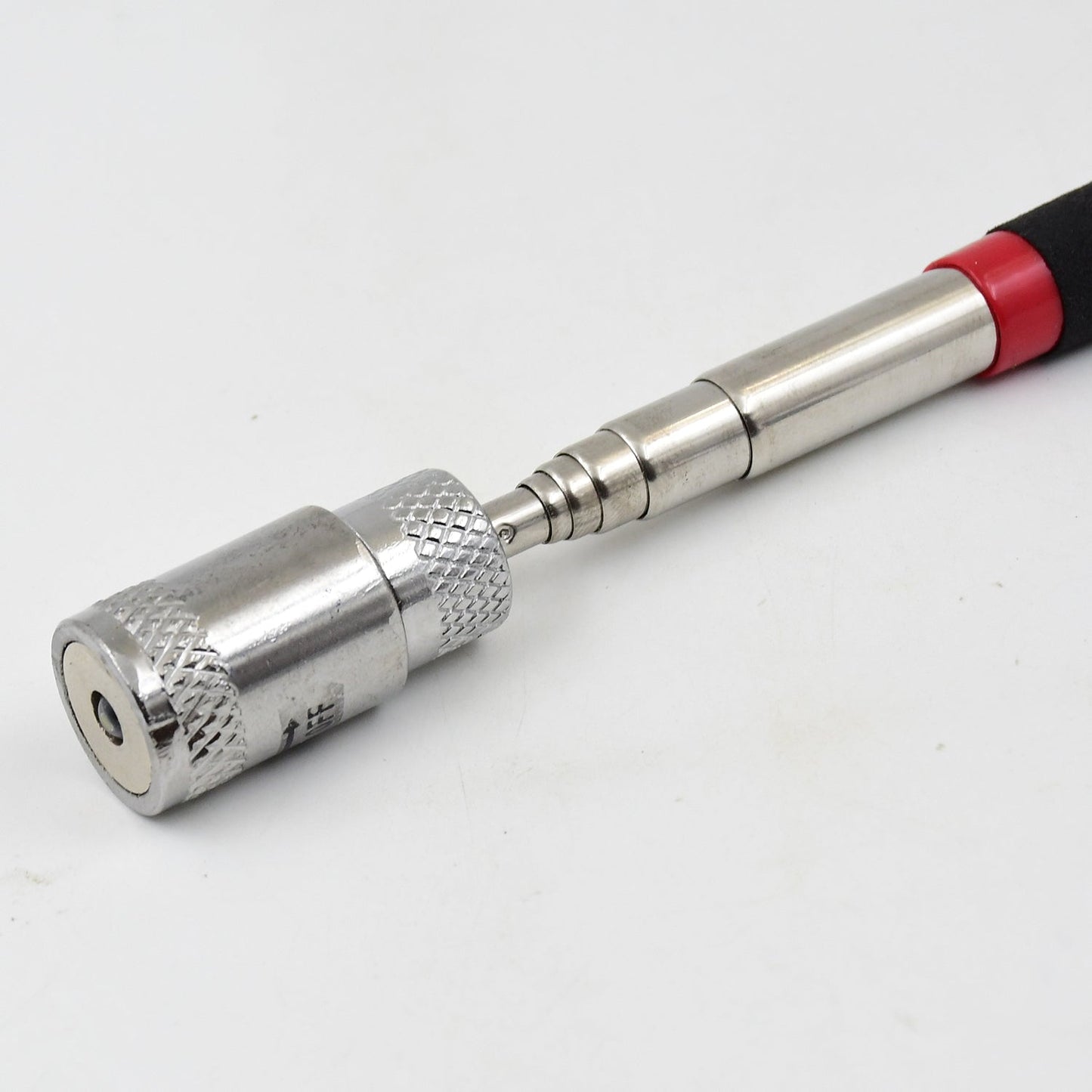 User demonstrating the telescopic reach of the magnetic retrieval tool.