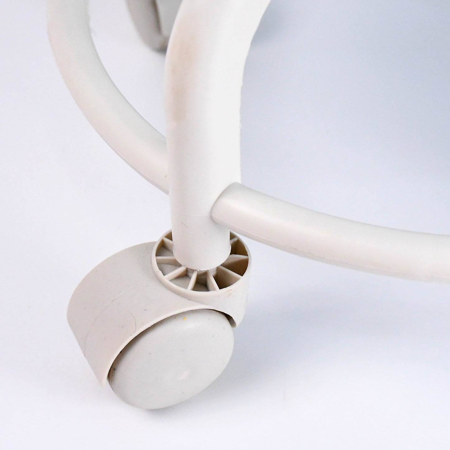 Side view of low rolling stool showing cushioned seat and sturdy wheels
