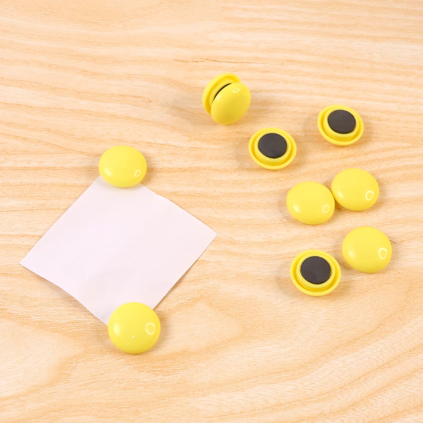 Side profile of a white round magnet, highlighting its compact and sleek design.