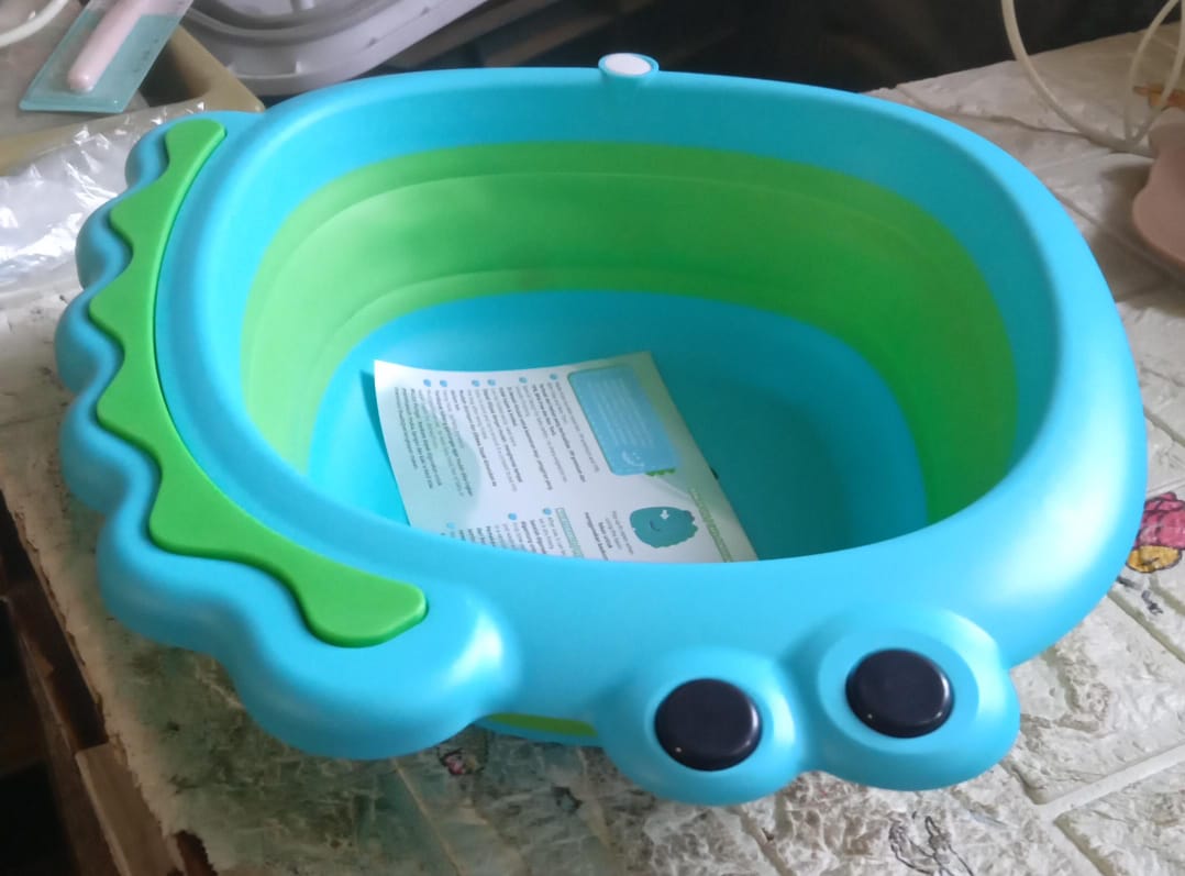 A side view of the practical foldable baby wash basin, highlighting its frog design.