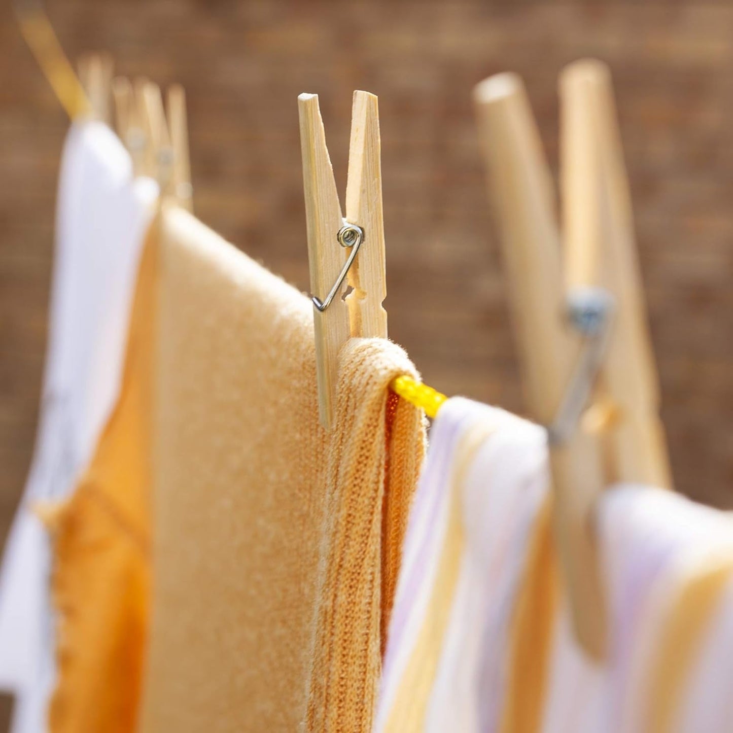 Bamboo cloth clips firmly gripping a piece of fabric, demonstrating strong hold.