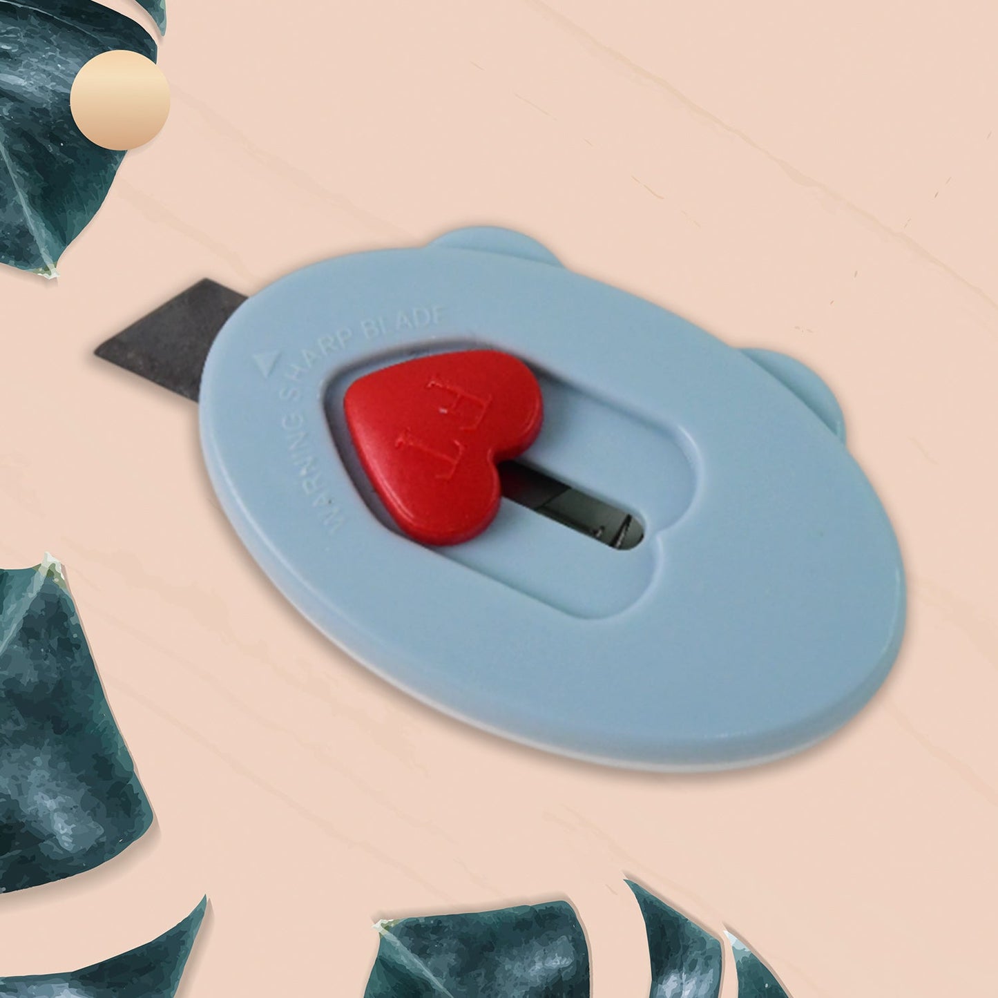 Heart-shaped safety lock on mini utility cutter for secure cutting