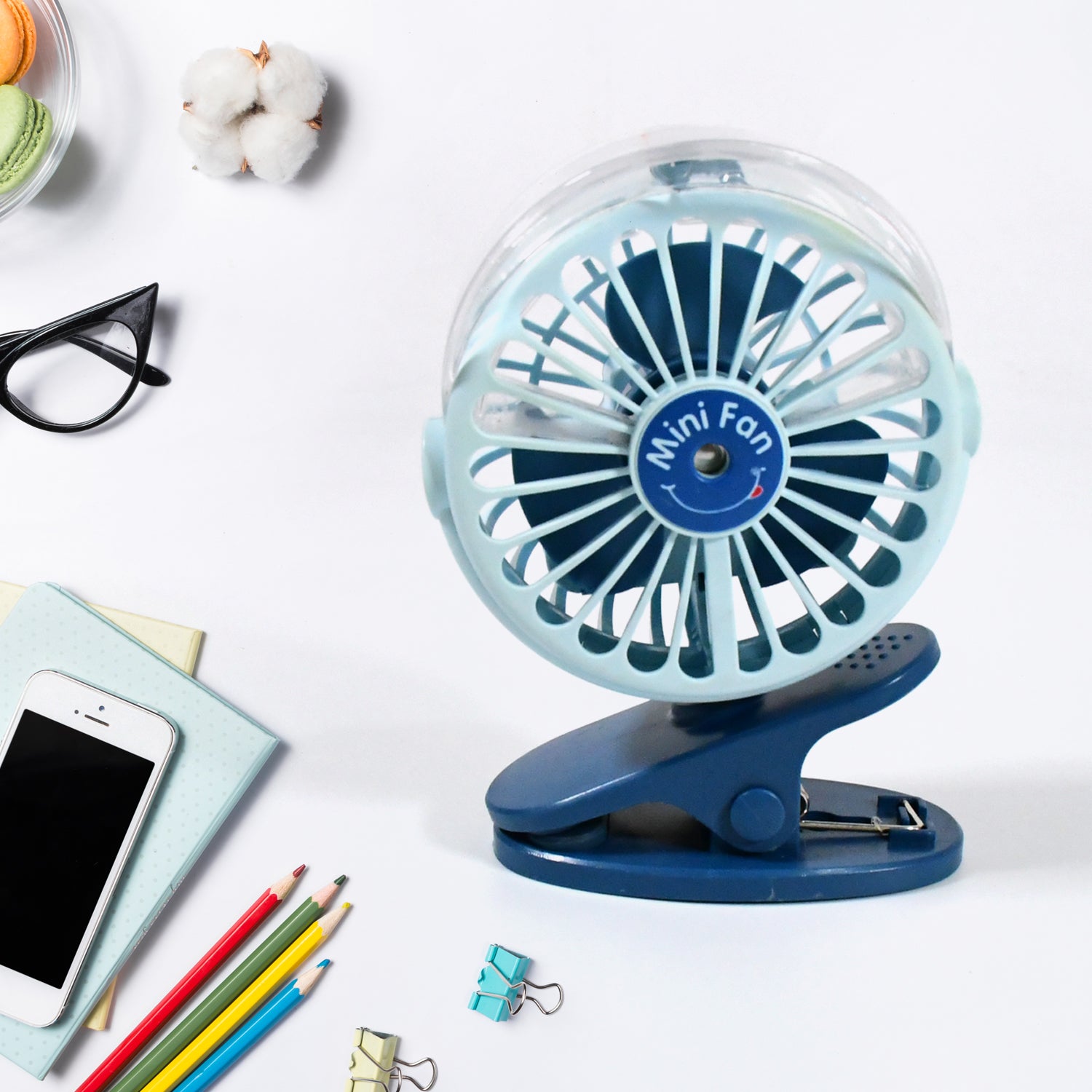 A person using the  rechargeable mini fan for personal cooling on a desk.