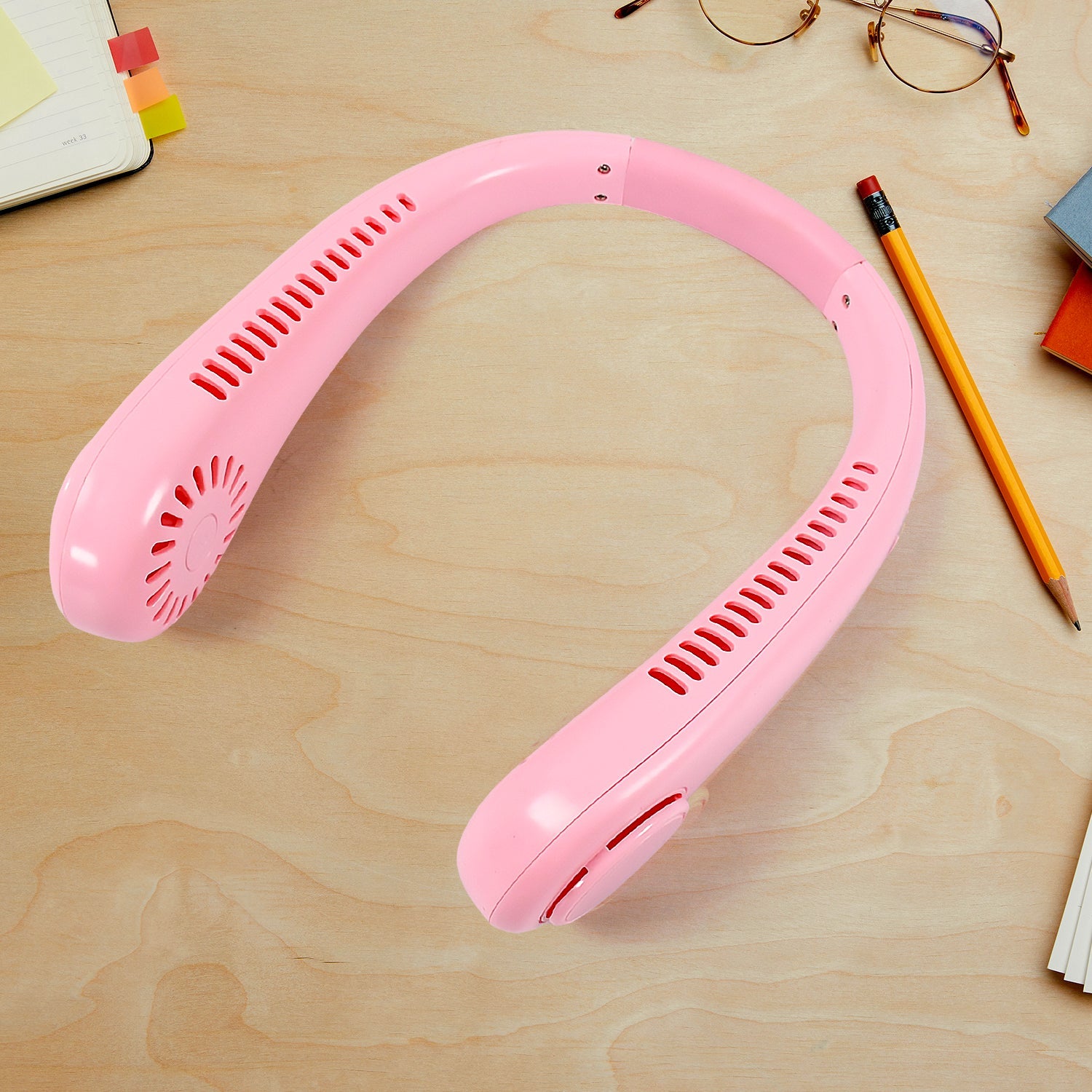 The bladeless neck fan in a resting position, highlighting its portability.