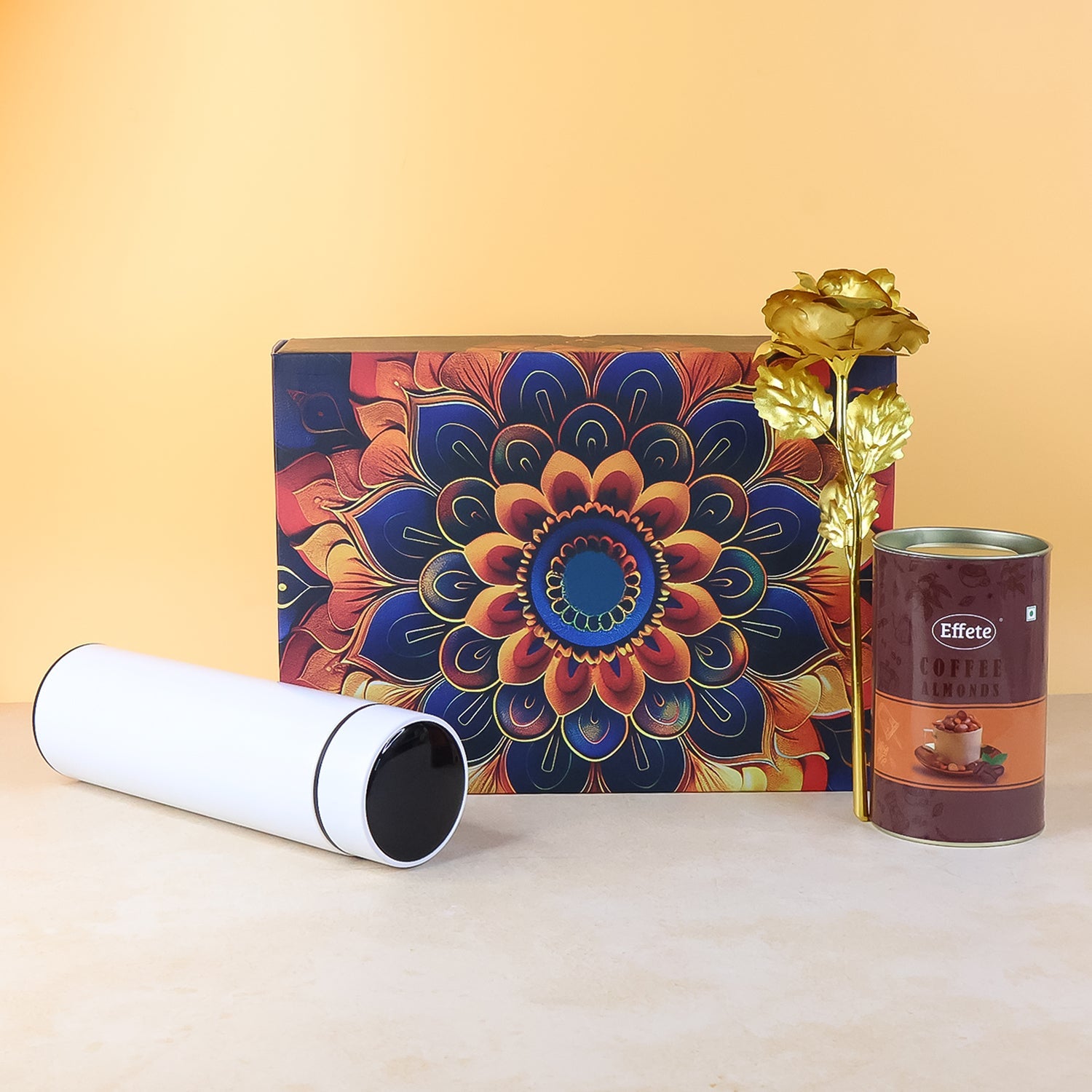 Festive gift hamper showcasing coffee almonds chocolate and stainless steel bottle with golden rose