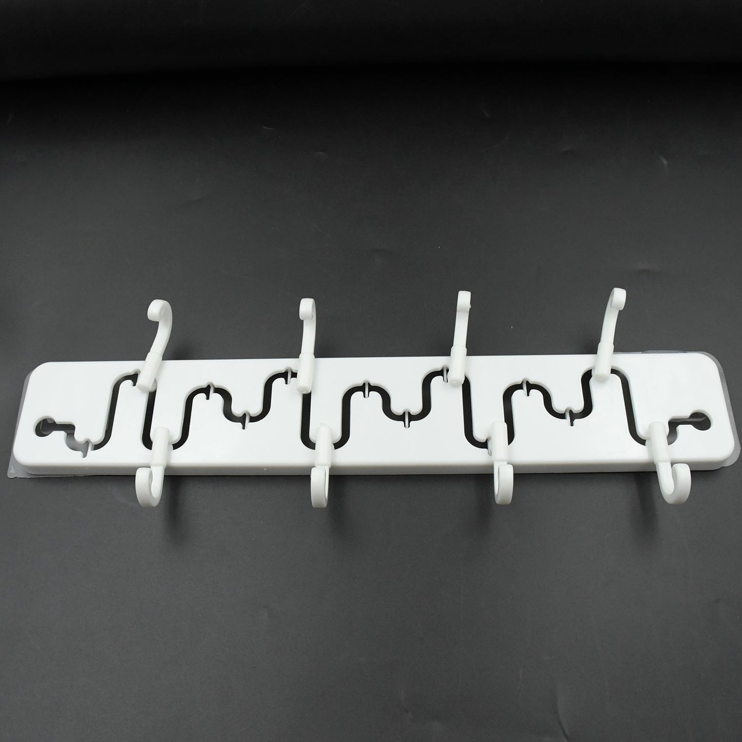 Modern adjustable wall hook installed in a bathroom, holding a towel.