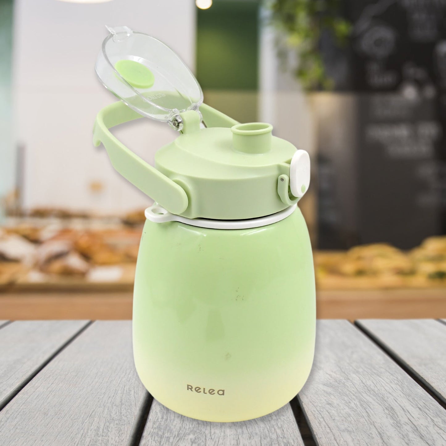 The 1200ml travel mug with its lid open, revealing a straw and included sticker sheet.
