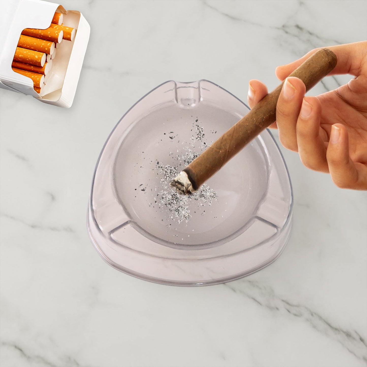 Close up on transparent white ashtray with cigarette rest slots