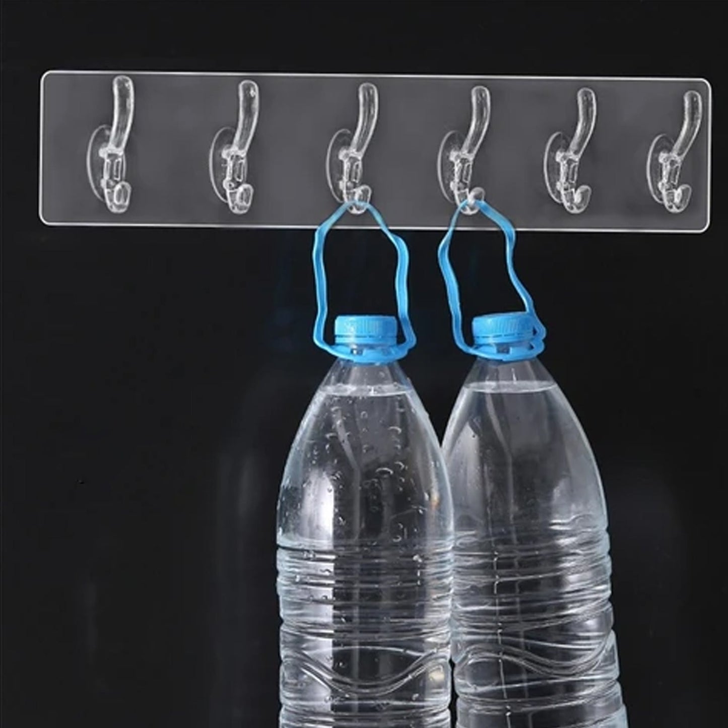 Transparent and golden 6-pin wall hook rail securely mounted on a white wall.