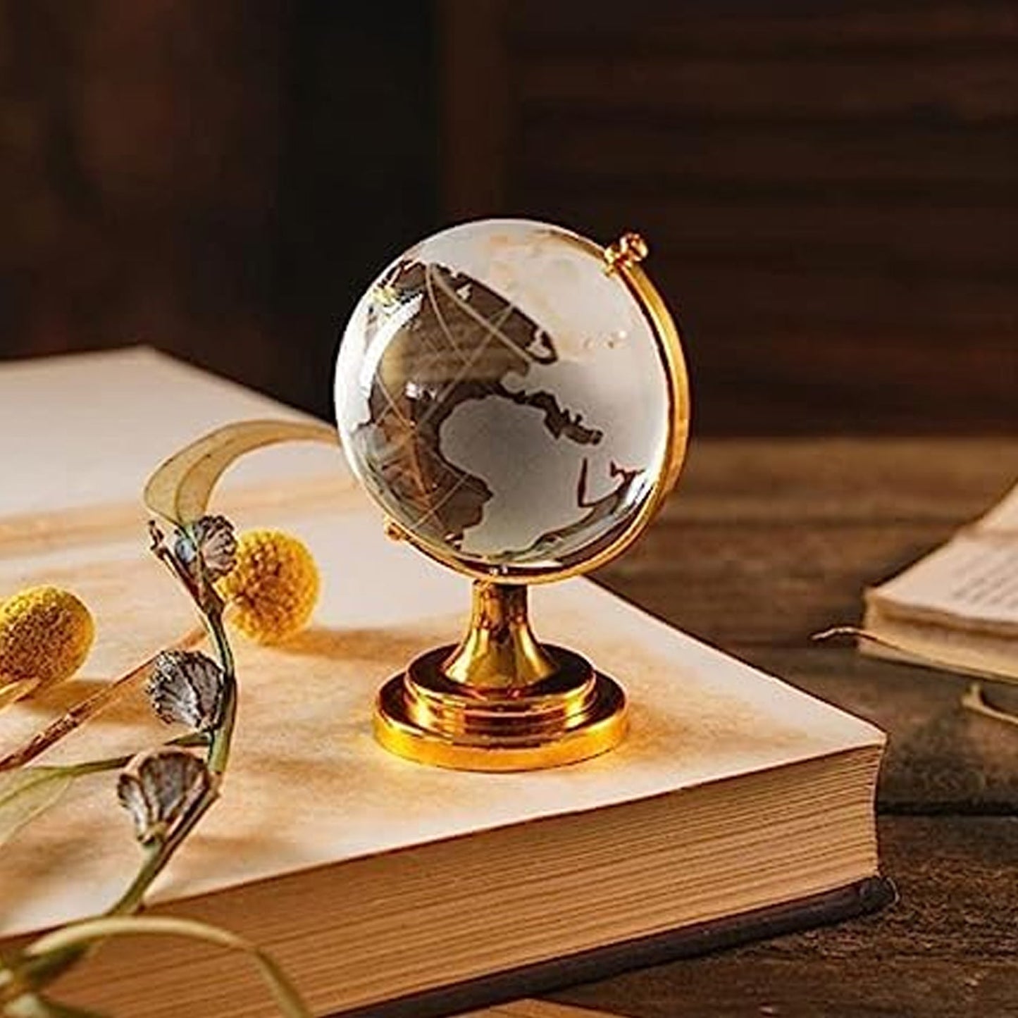 Crystal World Globe with golden stand, placed on a table as a sophisticated office decor item.
