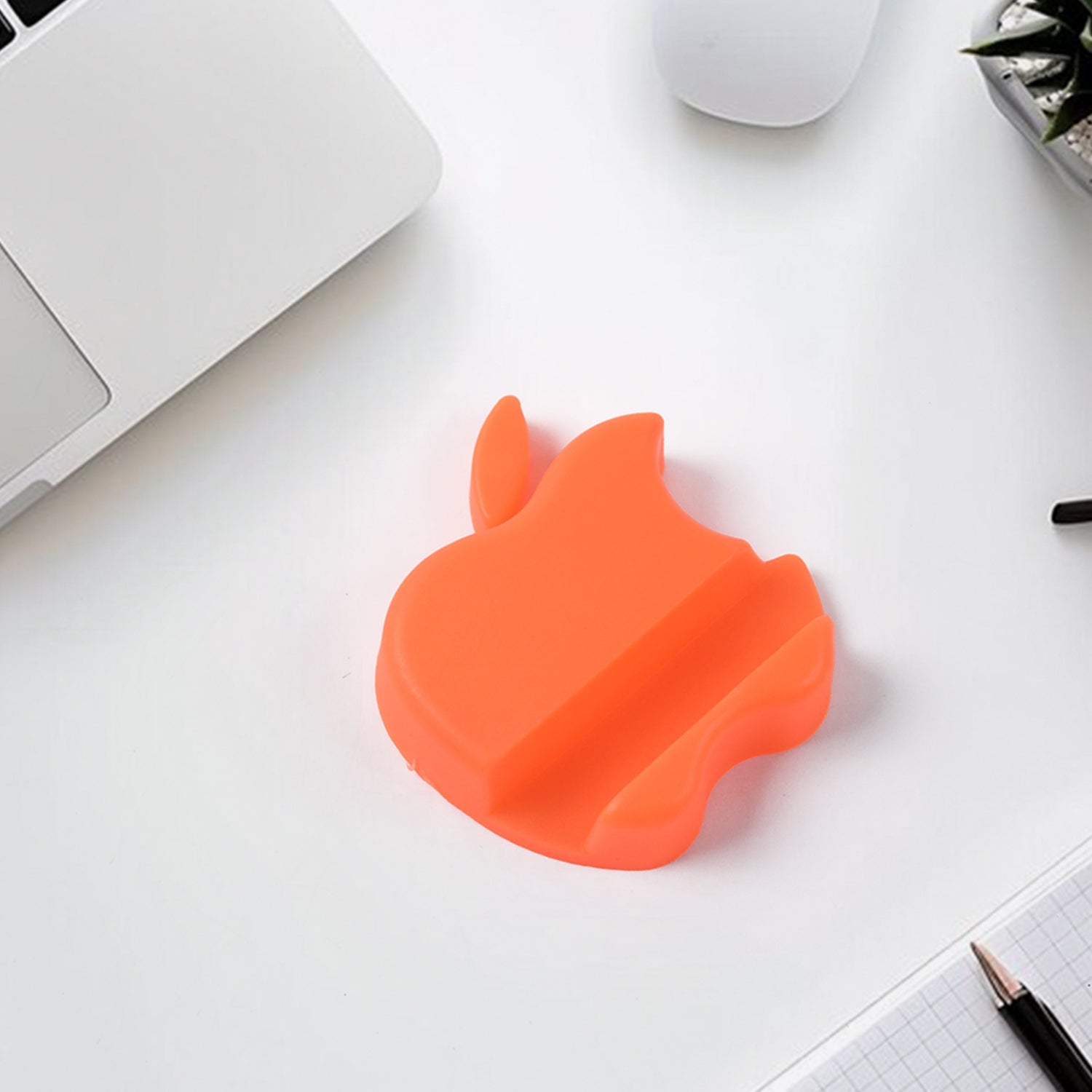 Apple-shaped plastic phone stand holding smartphone in landscape view