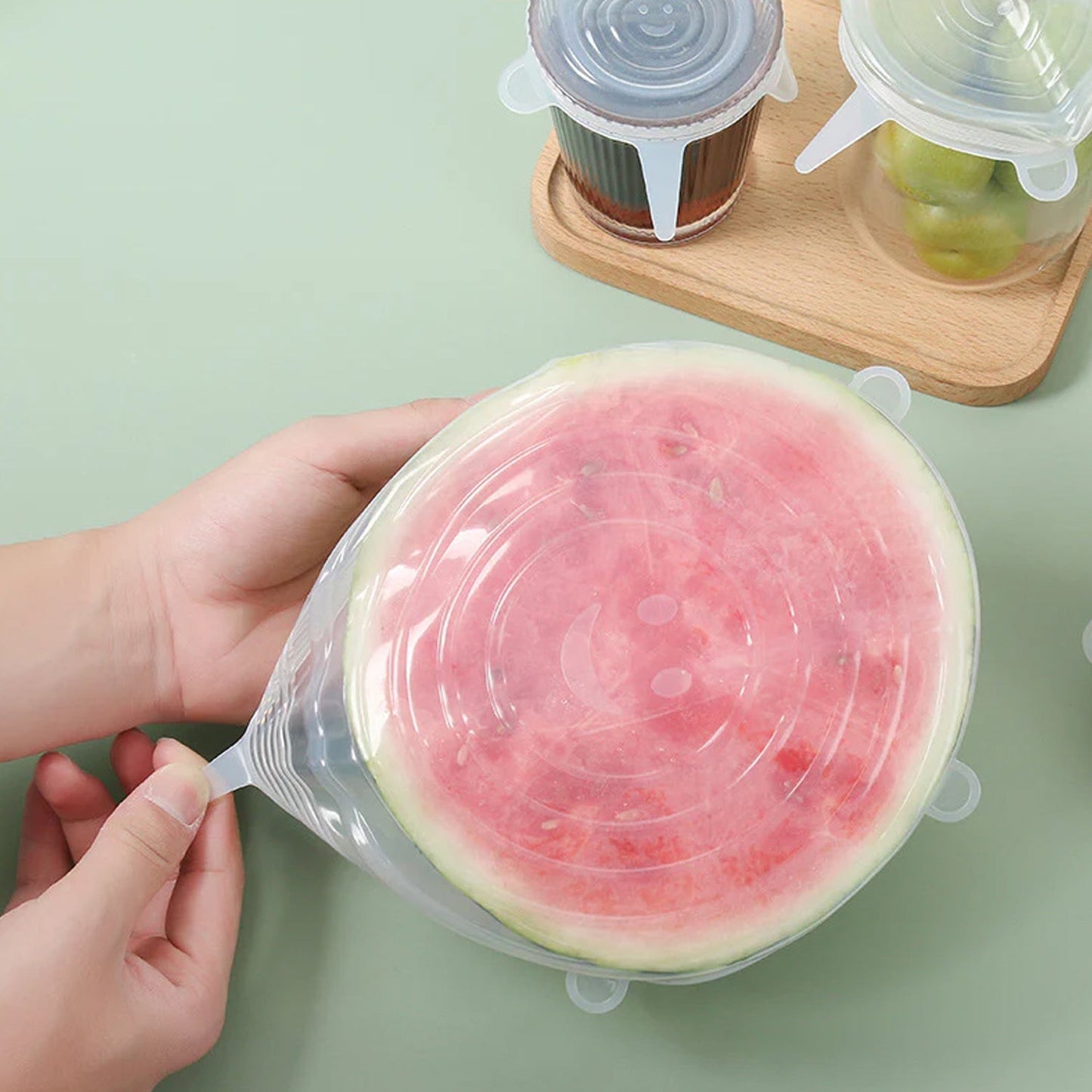 An overhead shot of different sizes of silicone food covers displayed on a clean kitchen counter.