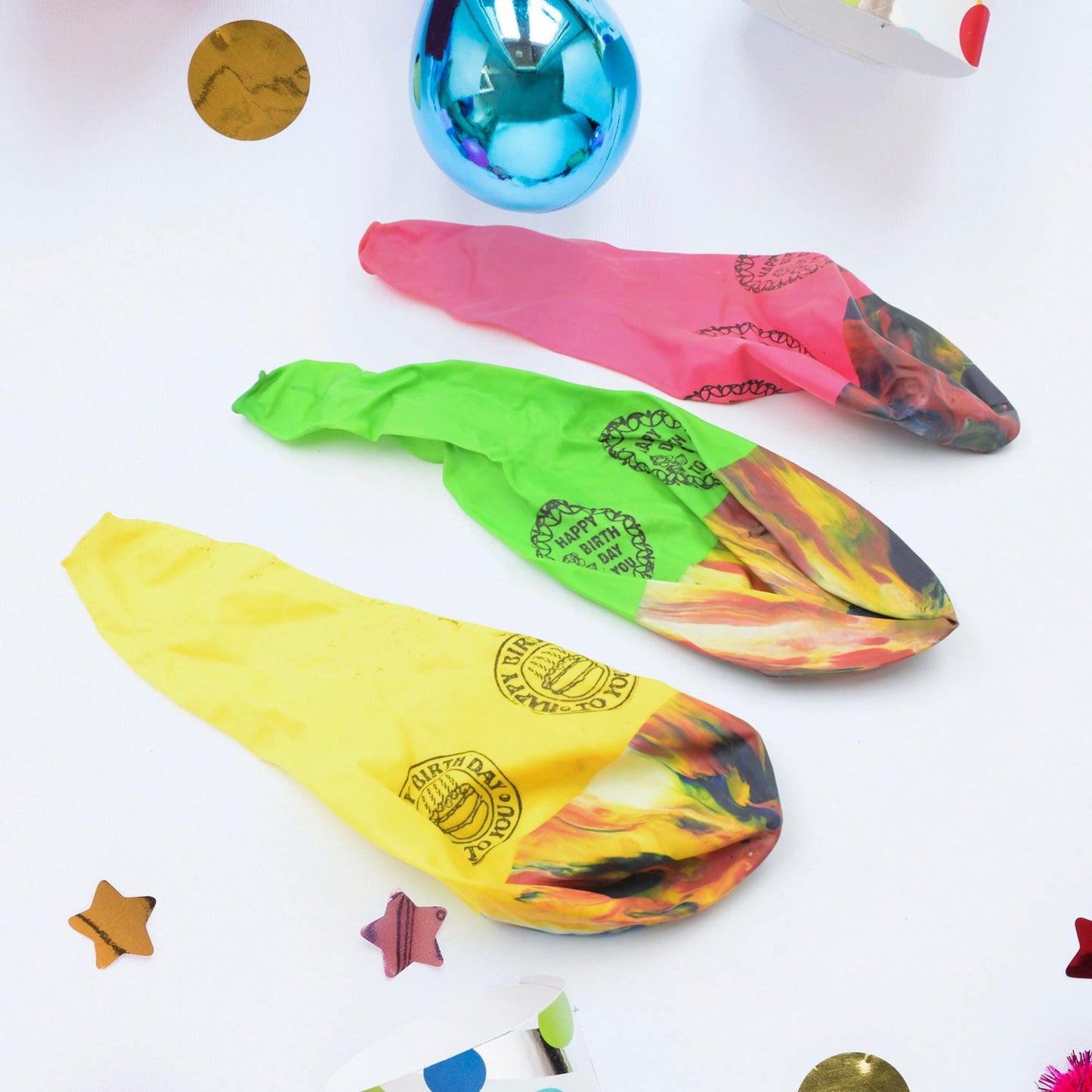 Multicolor rainbow party balloons floating against a light background.