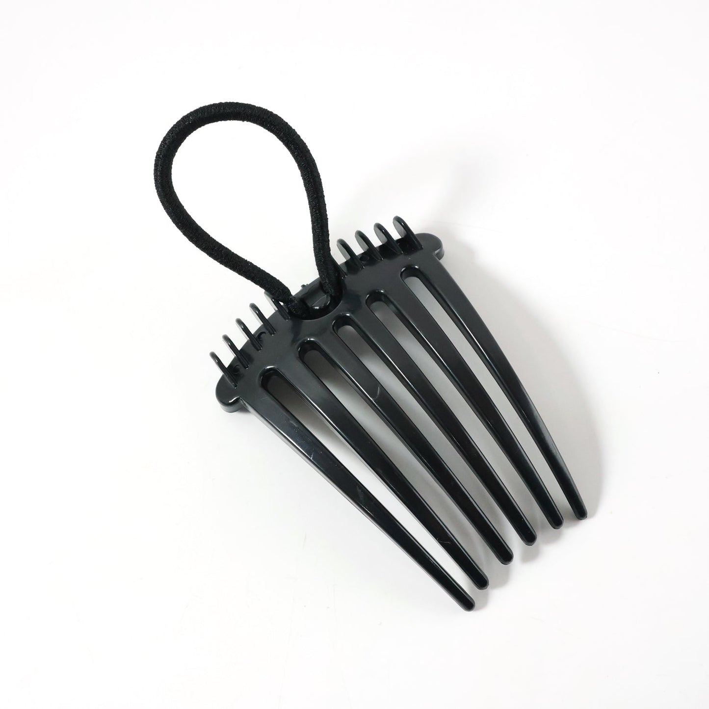 Hair styling comb clip securing hair in a voluminous bun style