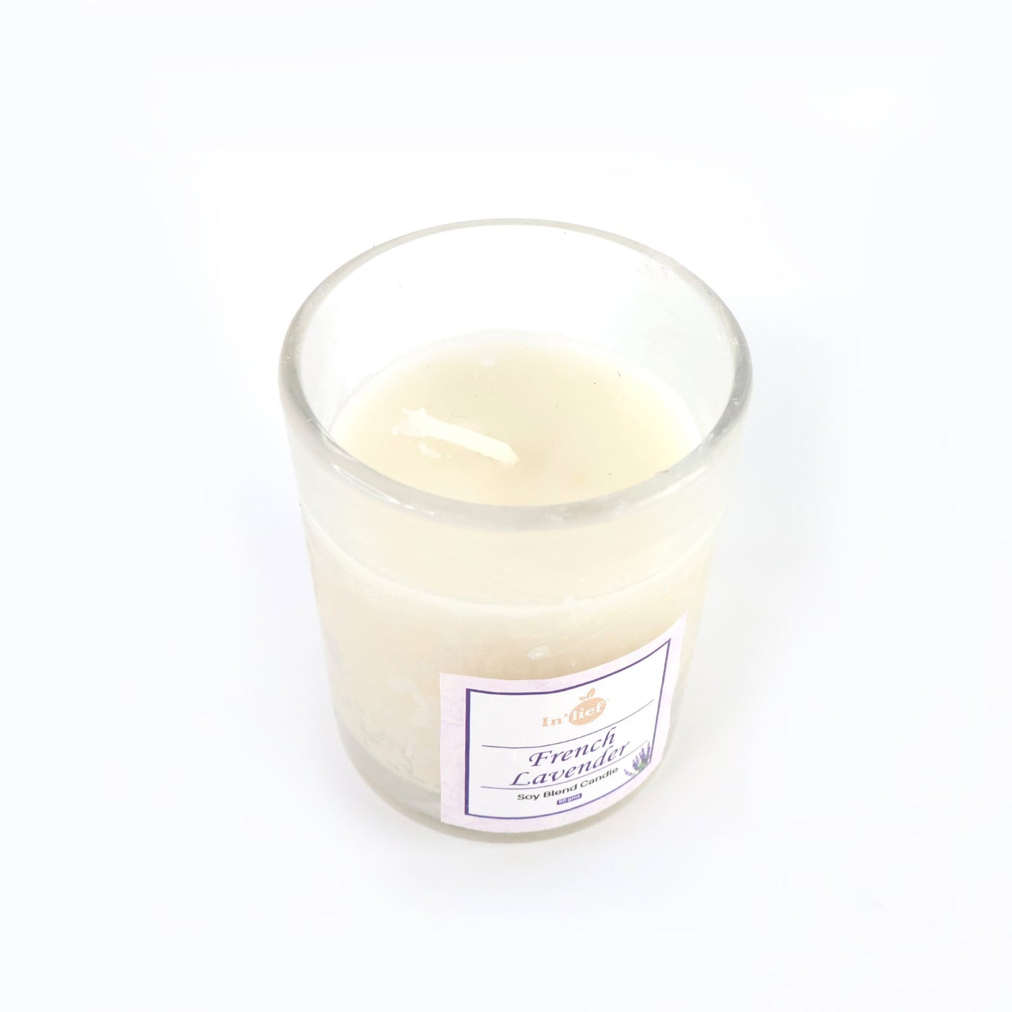Top view of French Lavender soy candle glowing with warm flame