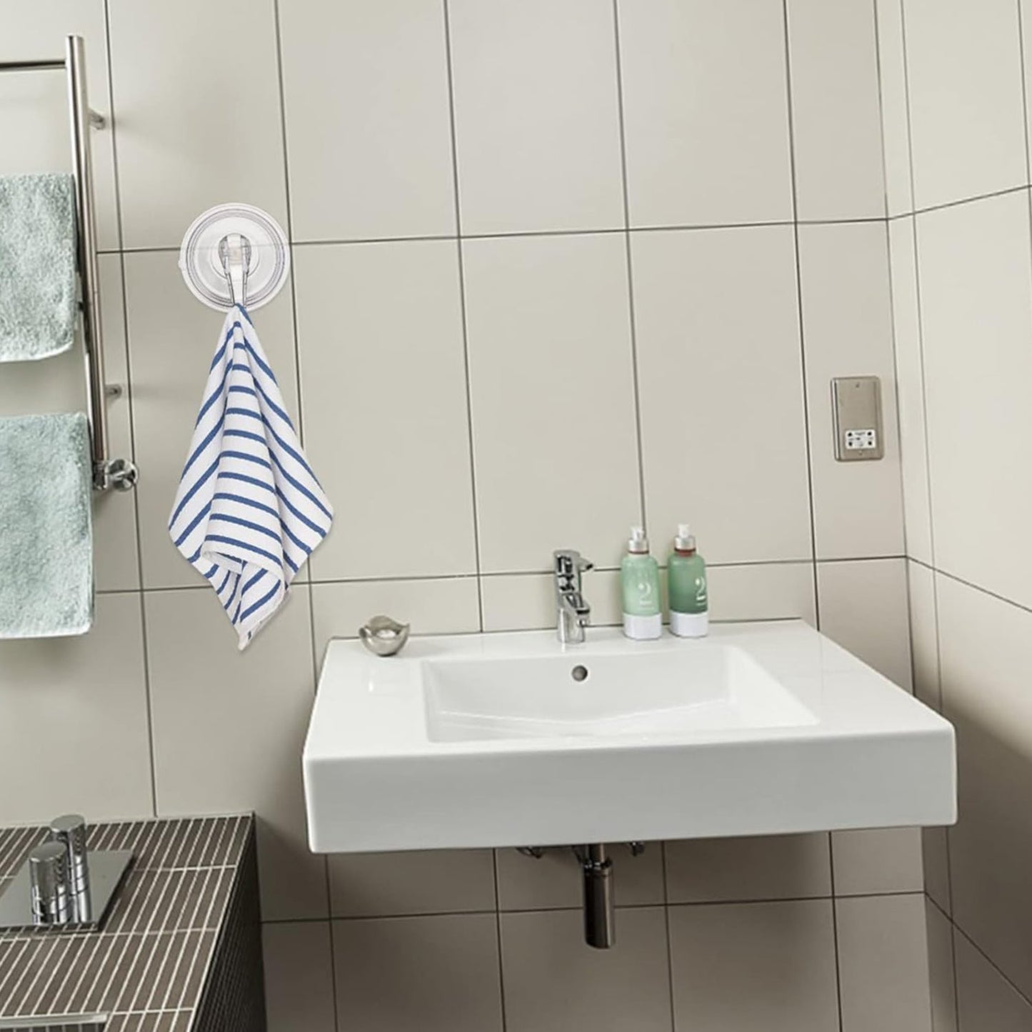 Strong plastic suction cup hook supporting towel on bathroom wall