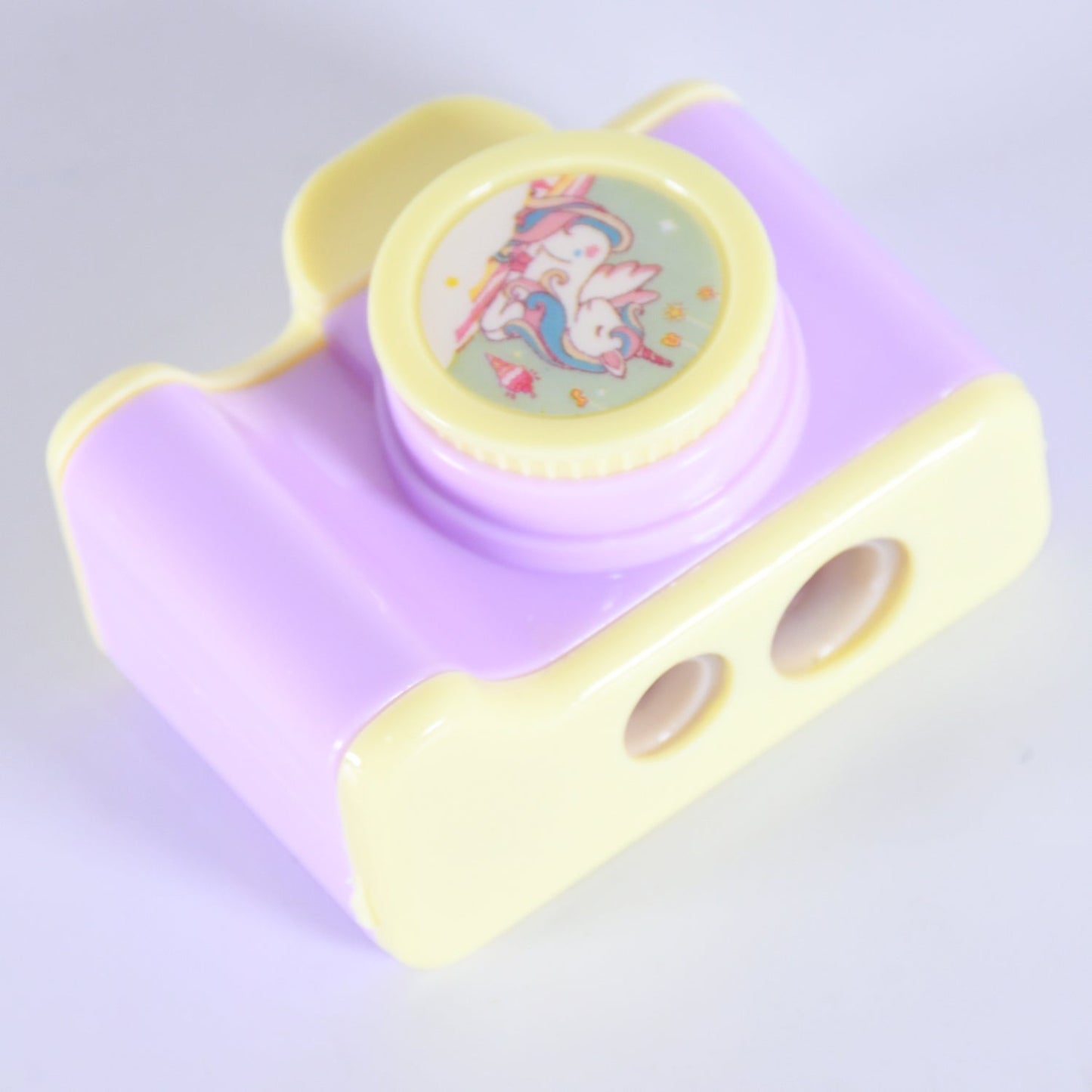 Side view of the camera shaped sharpener, highlighting its manual sharpening mechanism.