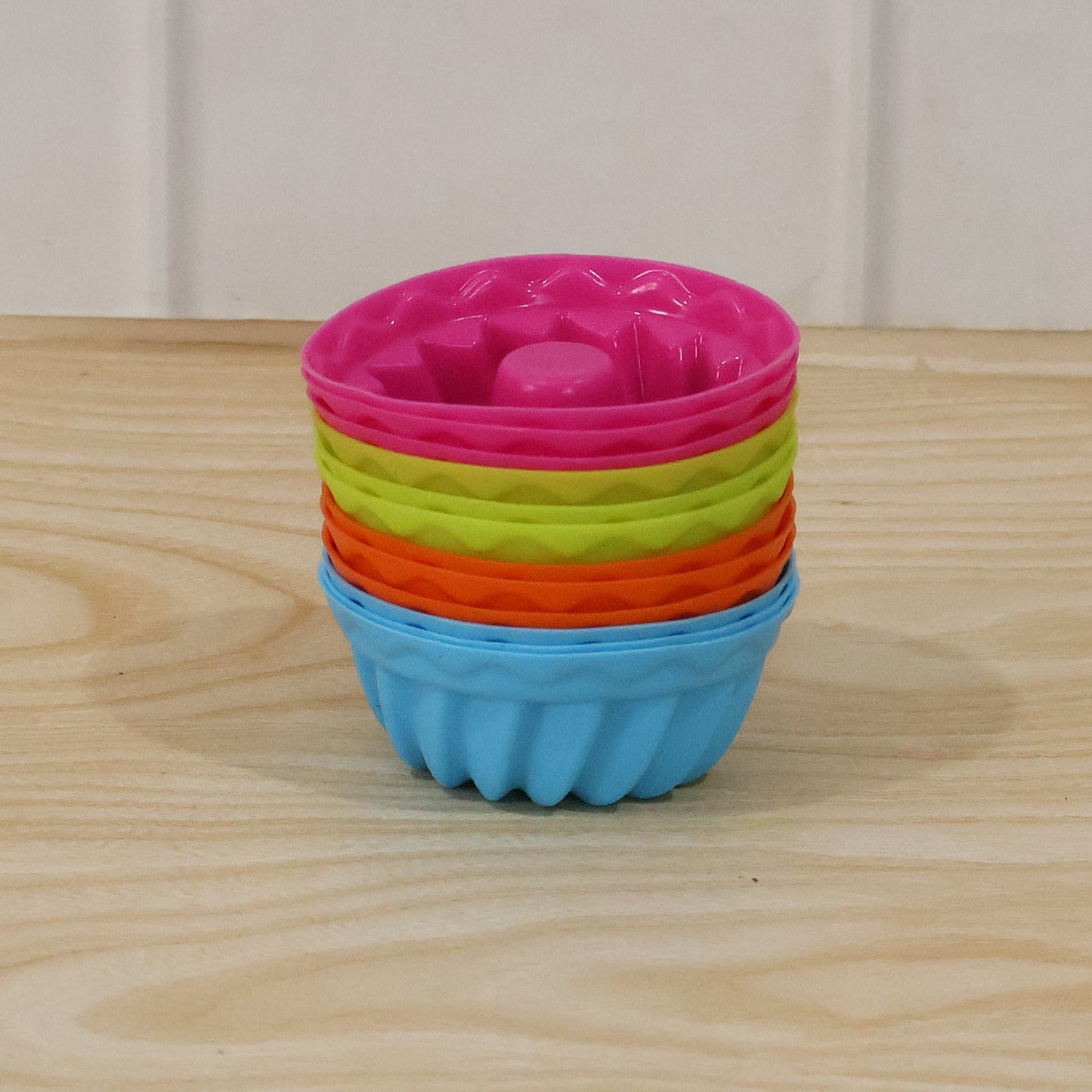 Stacked view of silicone cupcake moulds in bright colors