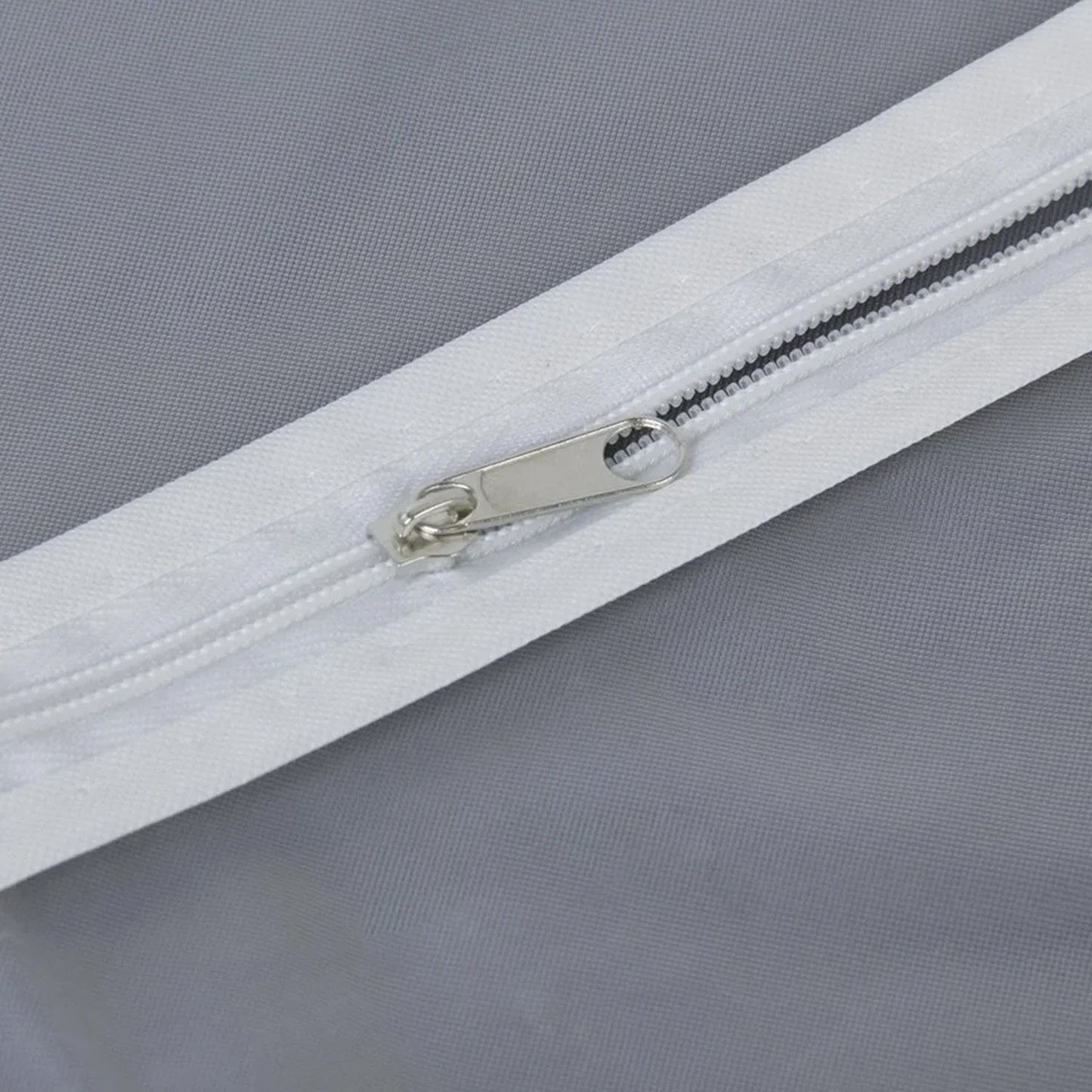 Closeup of full-length zipper on suit cover with breathable fabric.