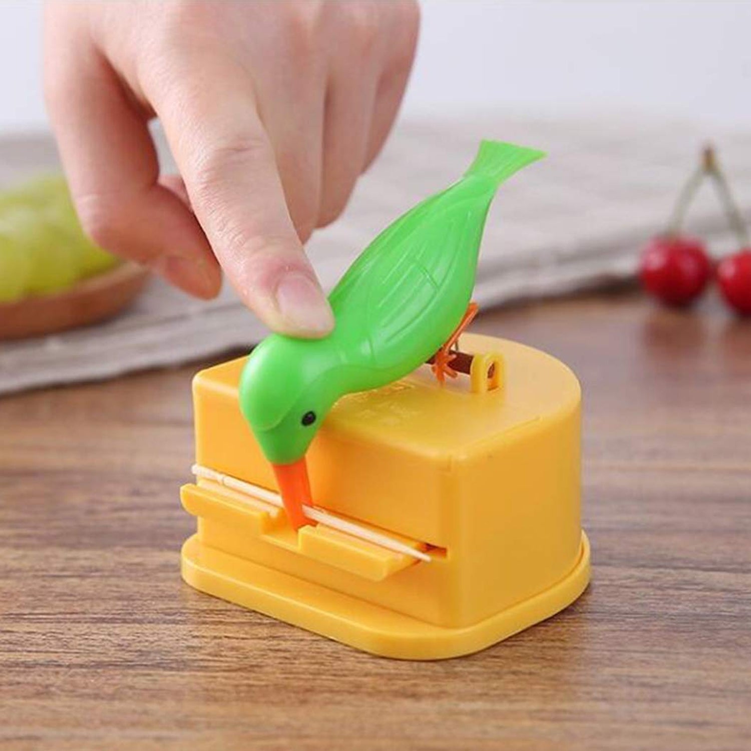 Demonstration of pressing button to dispense toothpick from bird dispenser