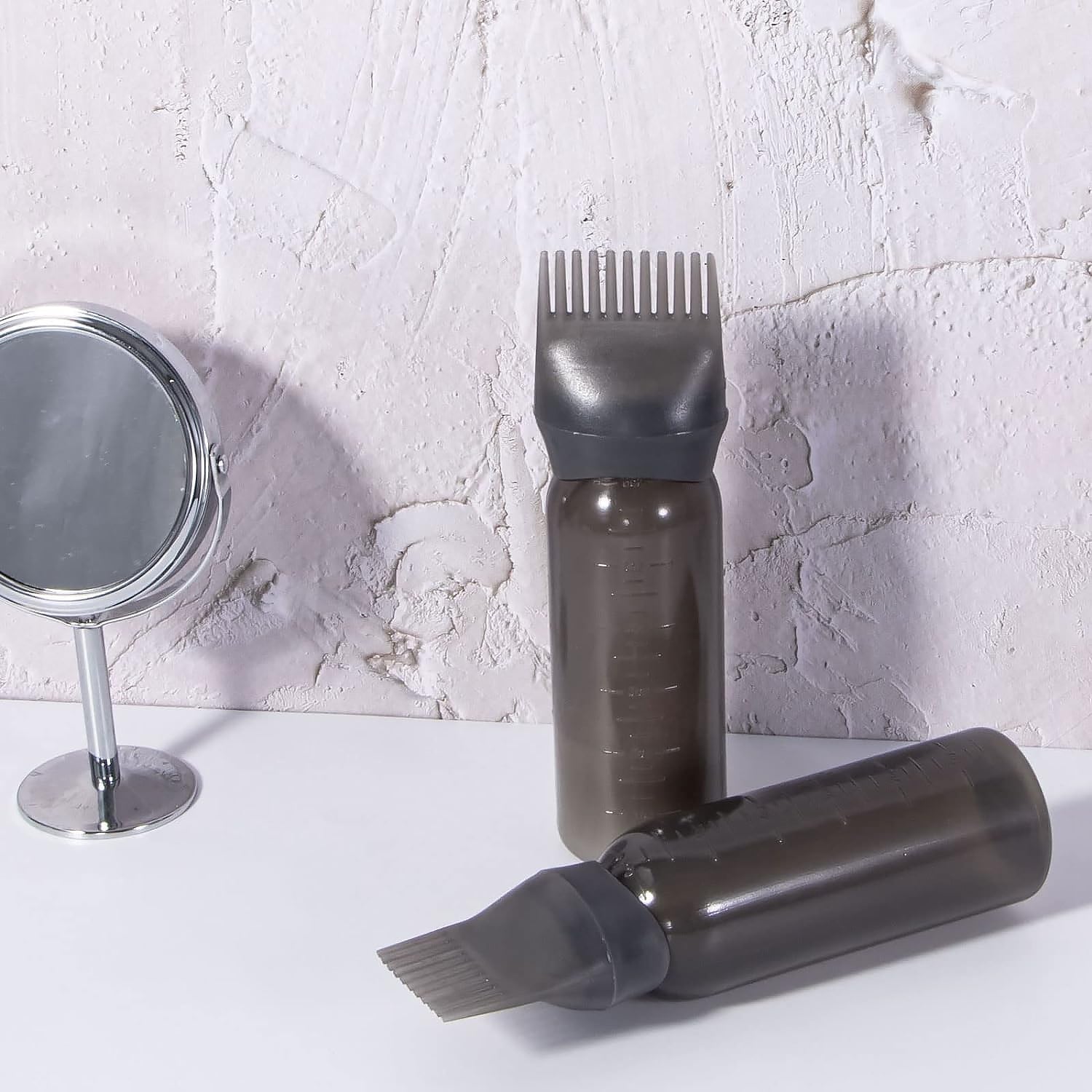 Plastic hair oil applicator bottle with a built-in comb brush for easy dispensing.