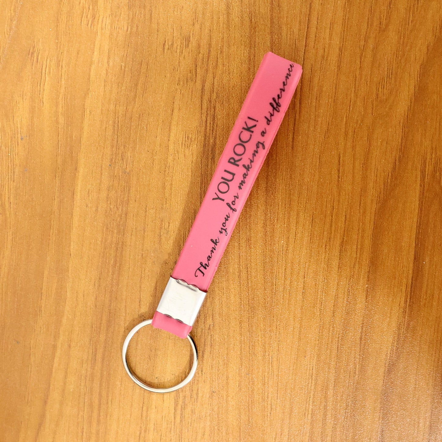 Silicone wrist strap keychain resting on a table with keys