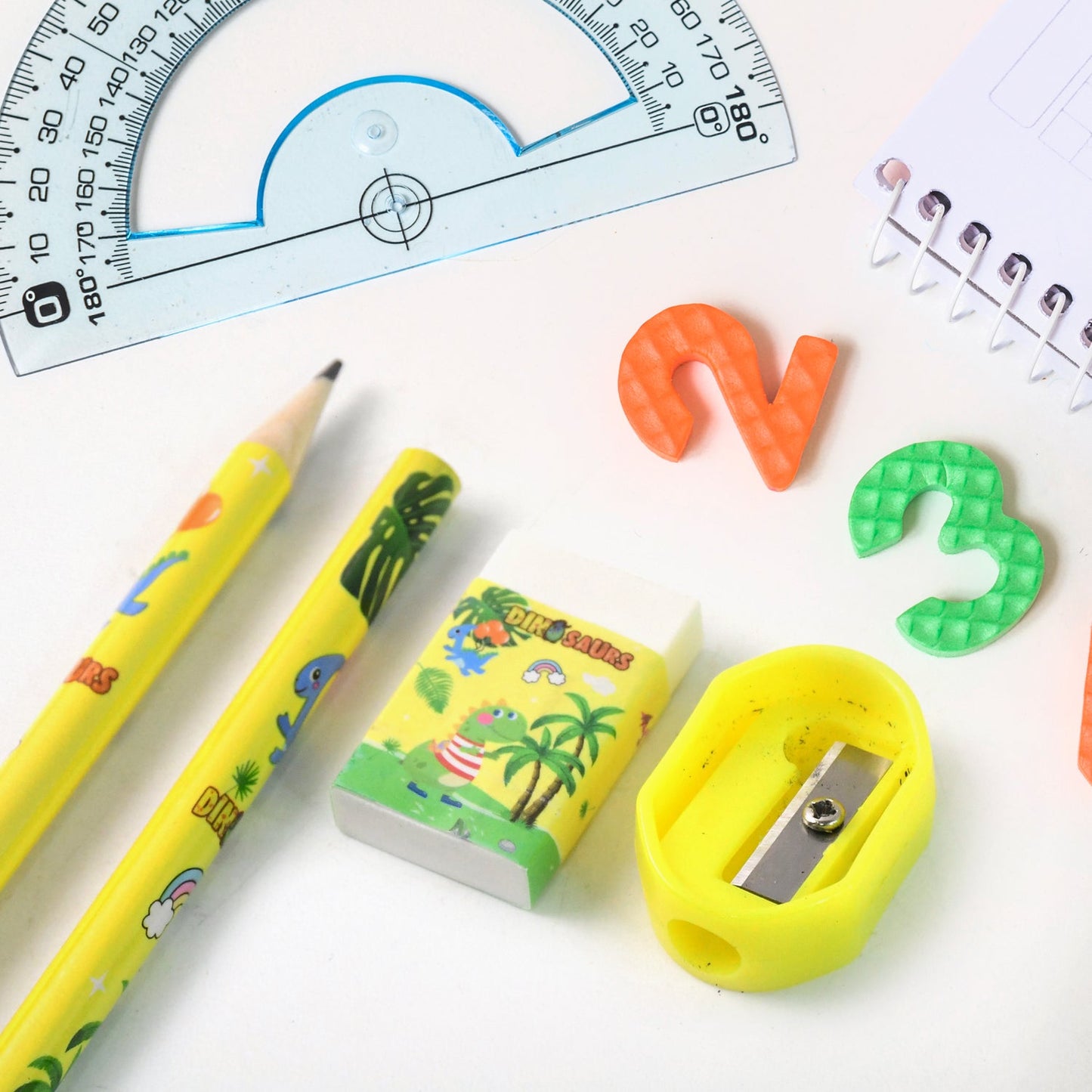 Multiple angles of dinosaur printed kids stationery set showing full kit