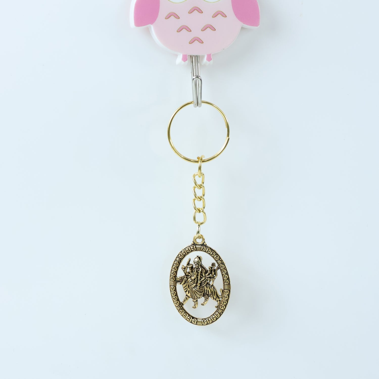 Angled view of Maa Durga Oval Frame Keychain showcasing metallic golden finish