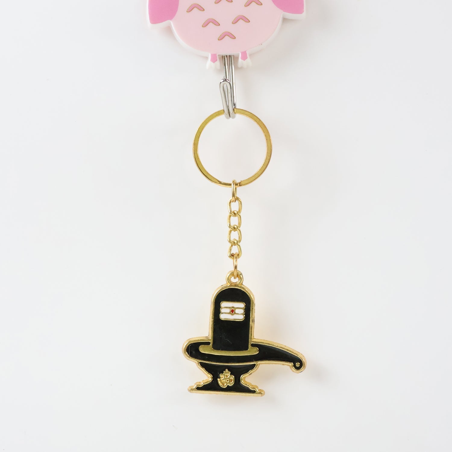 Golden Shivling keychain displayed on white surface showing metal craftsmanship