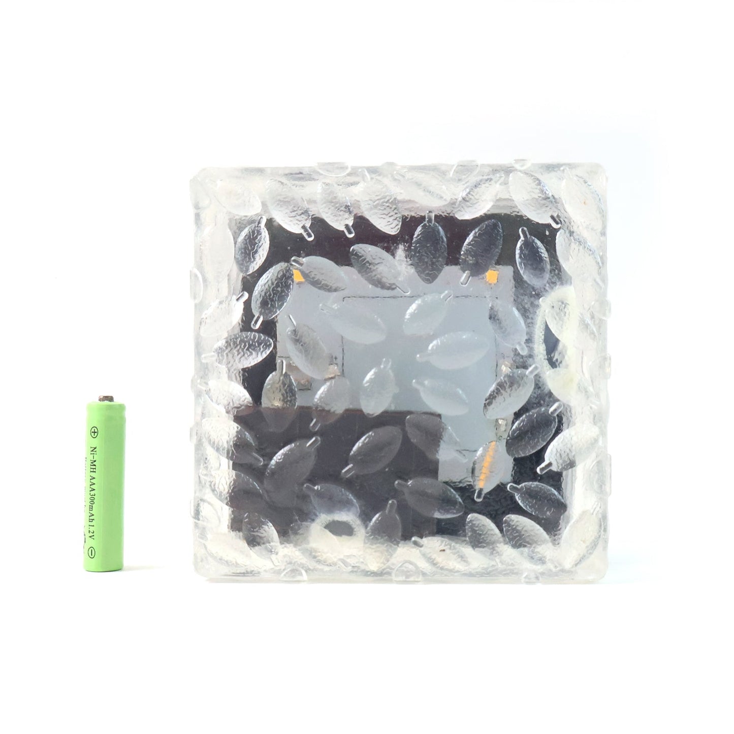 A solar powered ice cube light floating gently on water, ideal for pool decor.