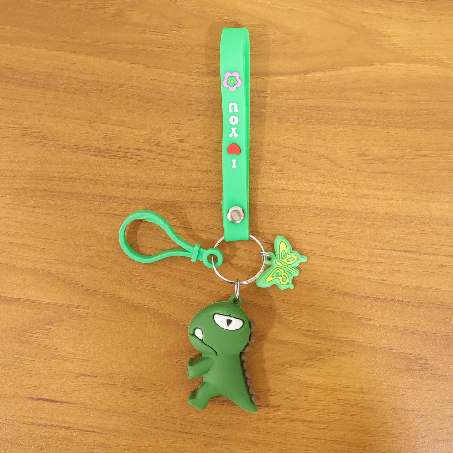 Front view of colorful dinosaur cartoon keychain with silicone strap