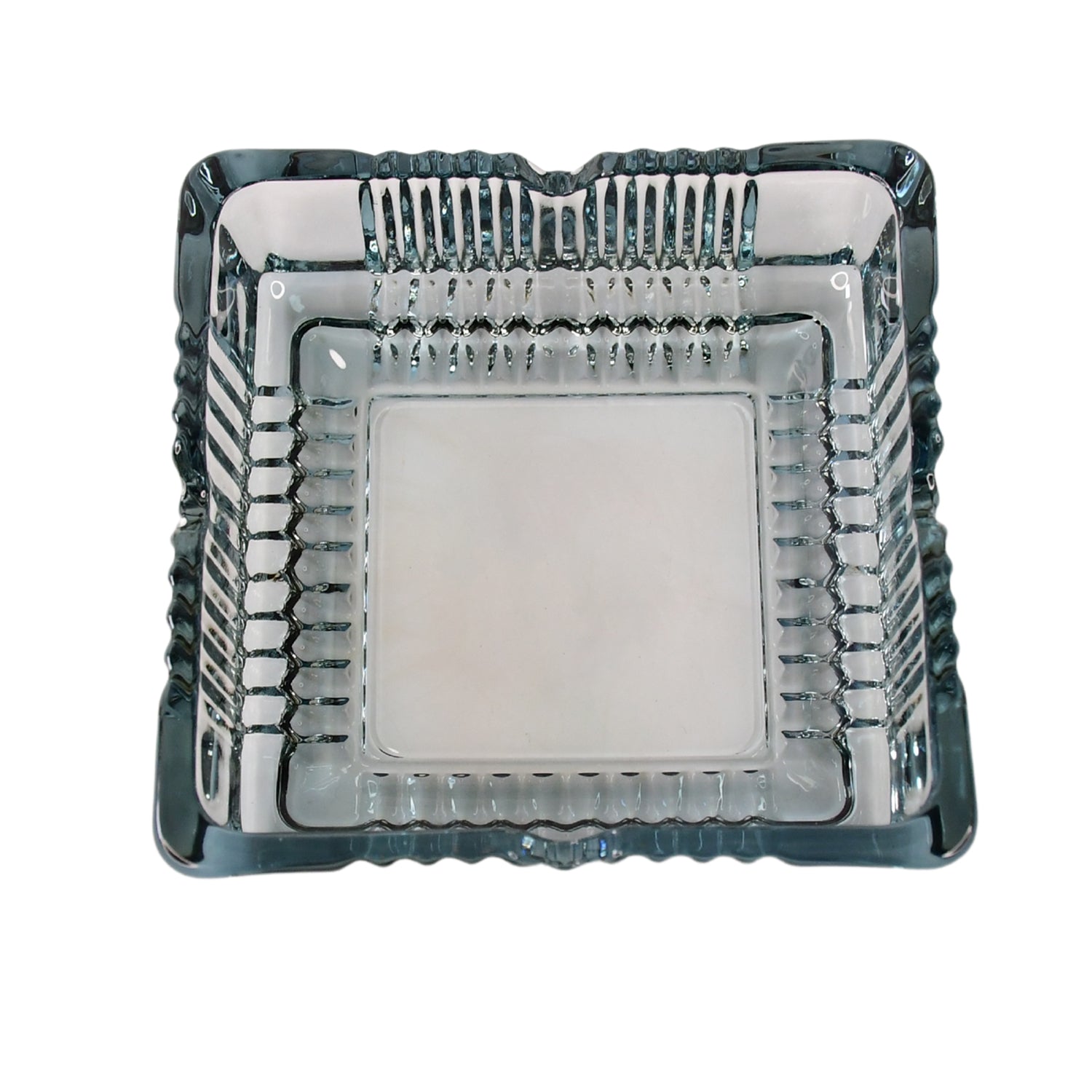 The elegant square glass ashtray displayed in a home or office setting.
