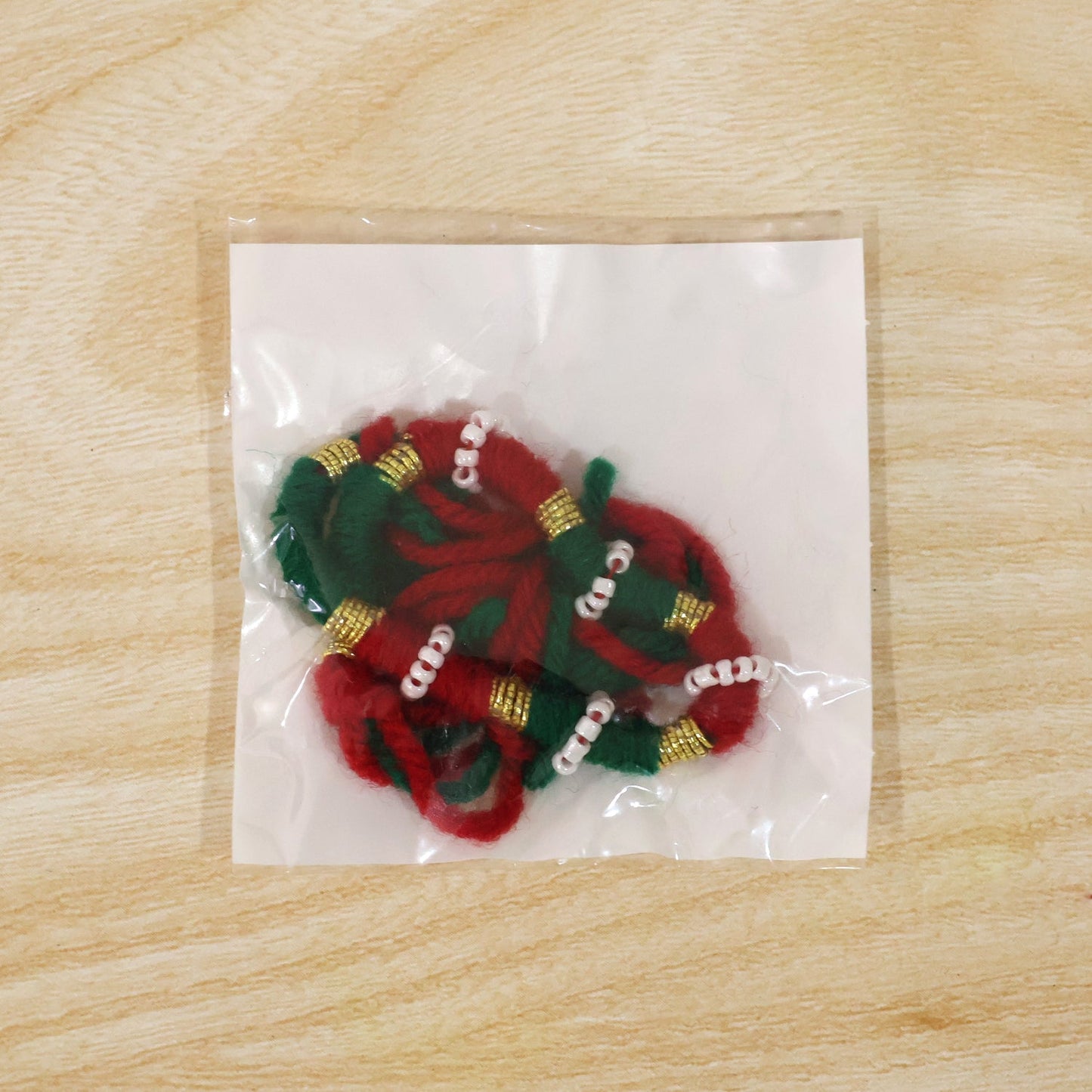 Closeup of golden beads on red green thread rakhi