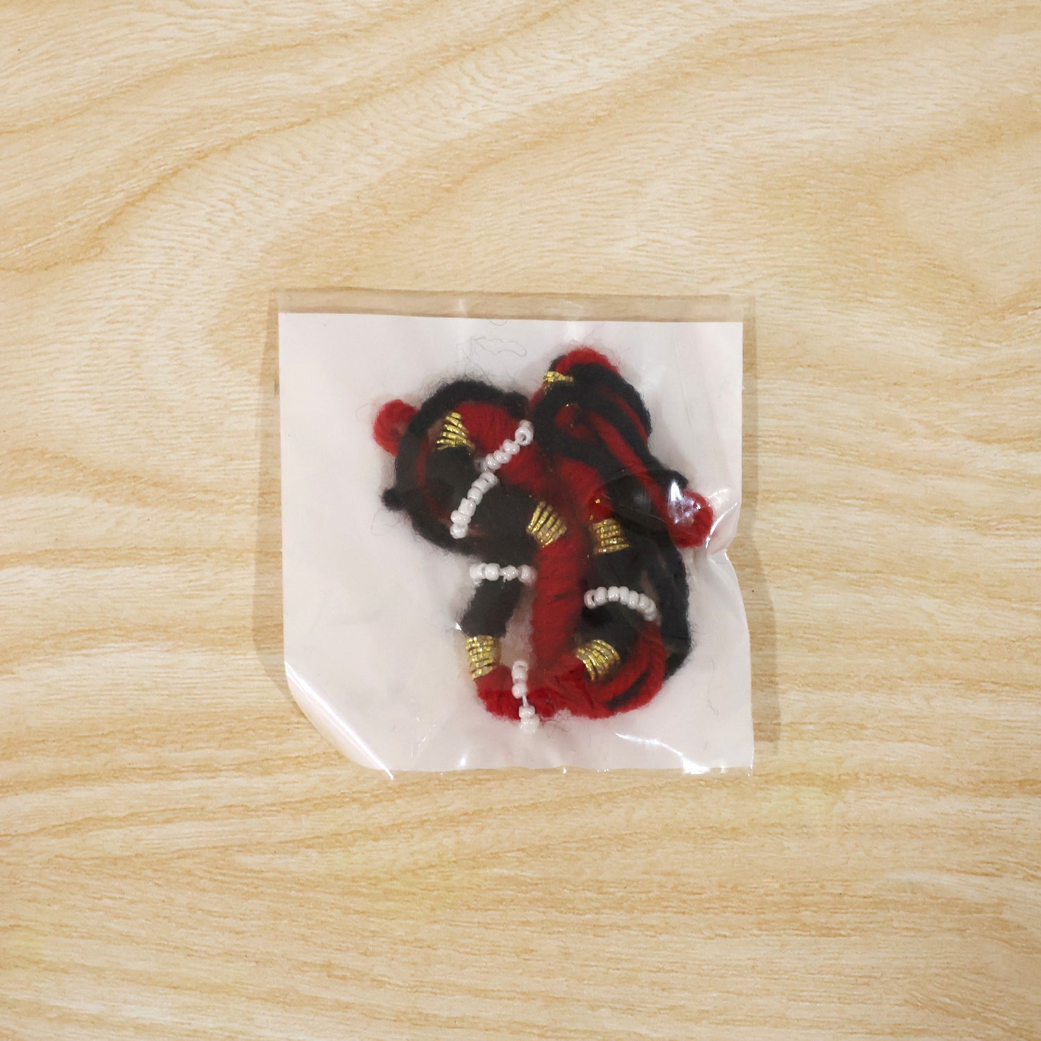 Festive red and black thread rakhi for brother with golden accents
