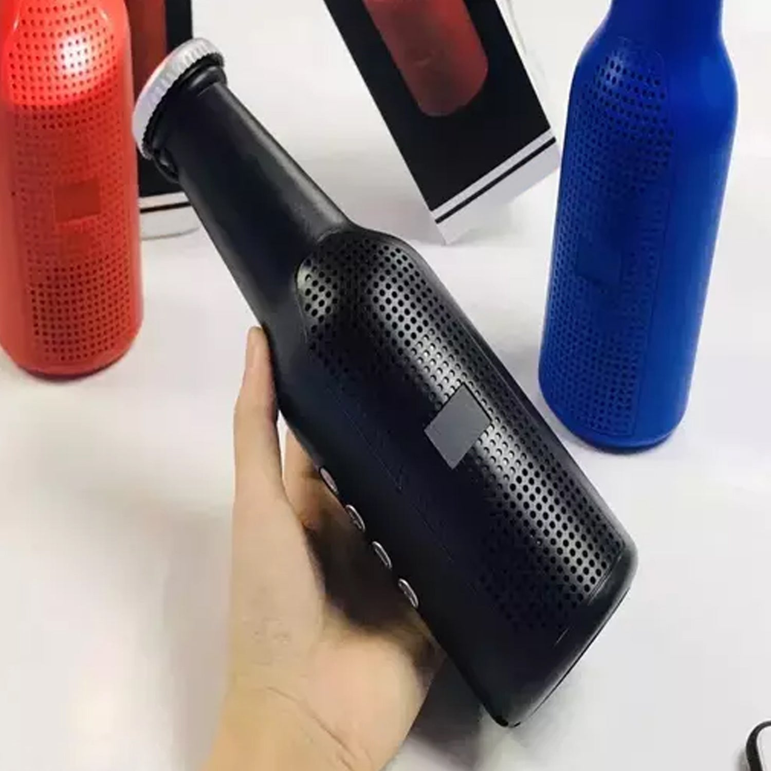 Lifestyle shot of the Audila Bottle Bluetooth Speaker being held outdoors.