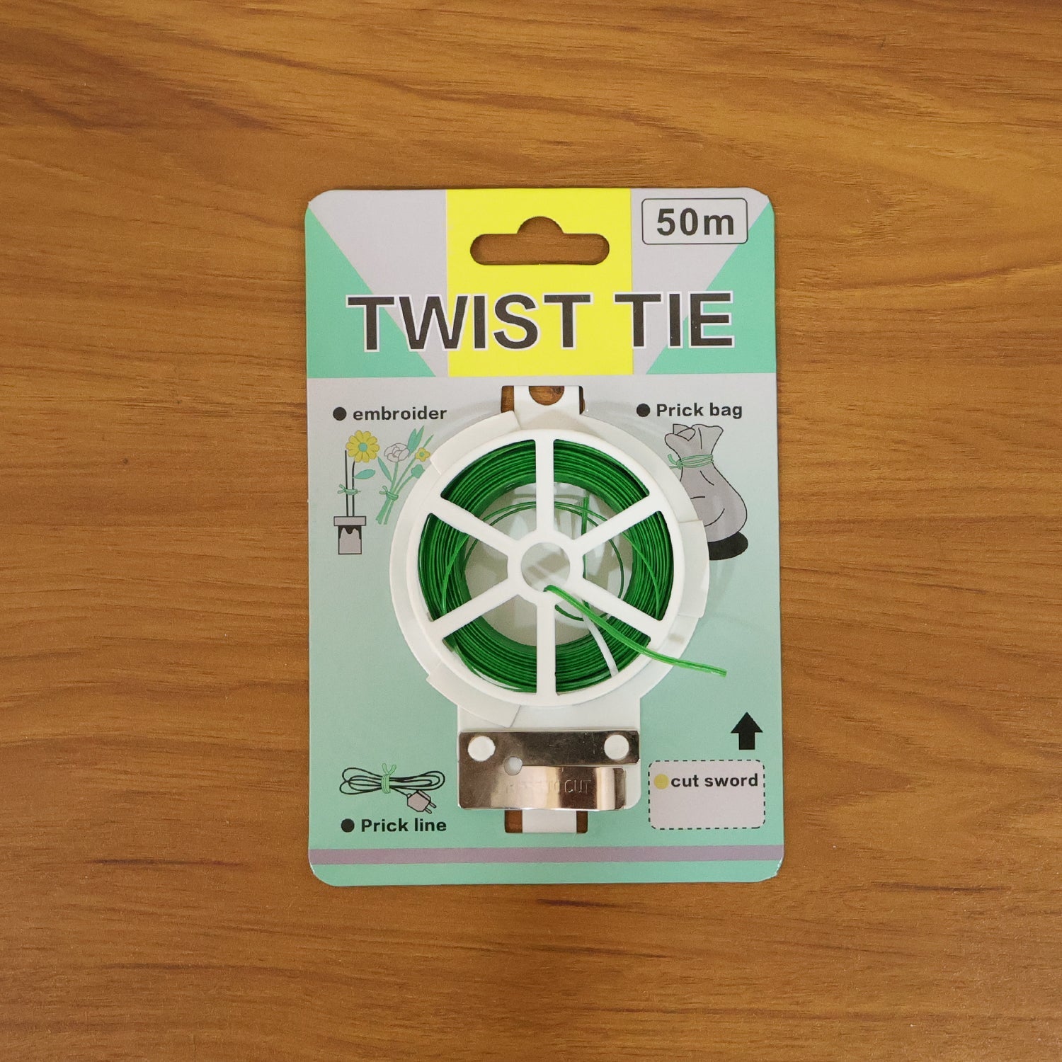 Green flexible twist tie wire roll with built-in cutter in hand