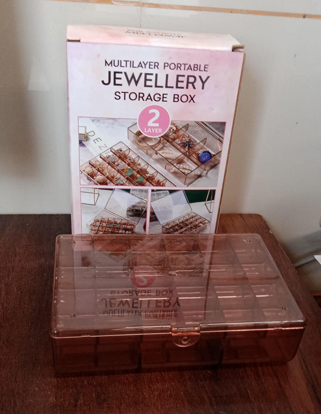 Compact clear acrylic storage box with a secure latch, showcasing its portability.