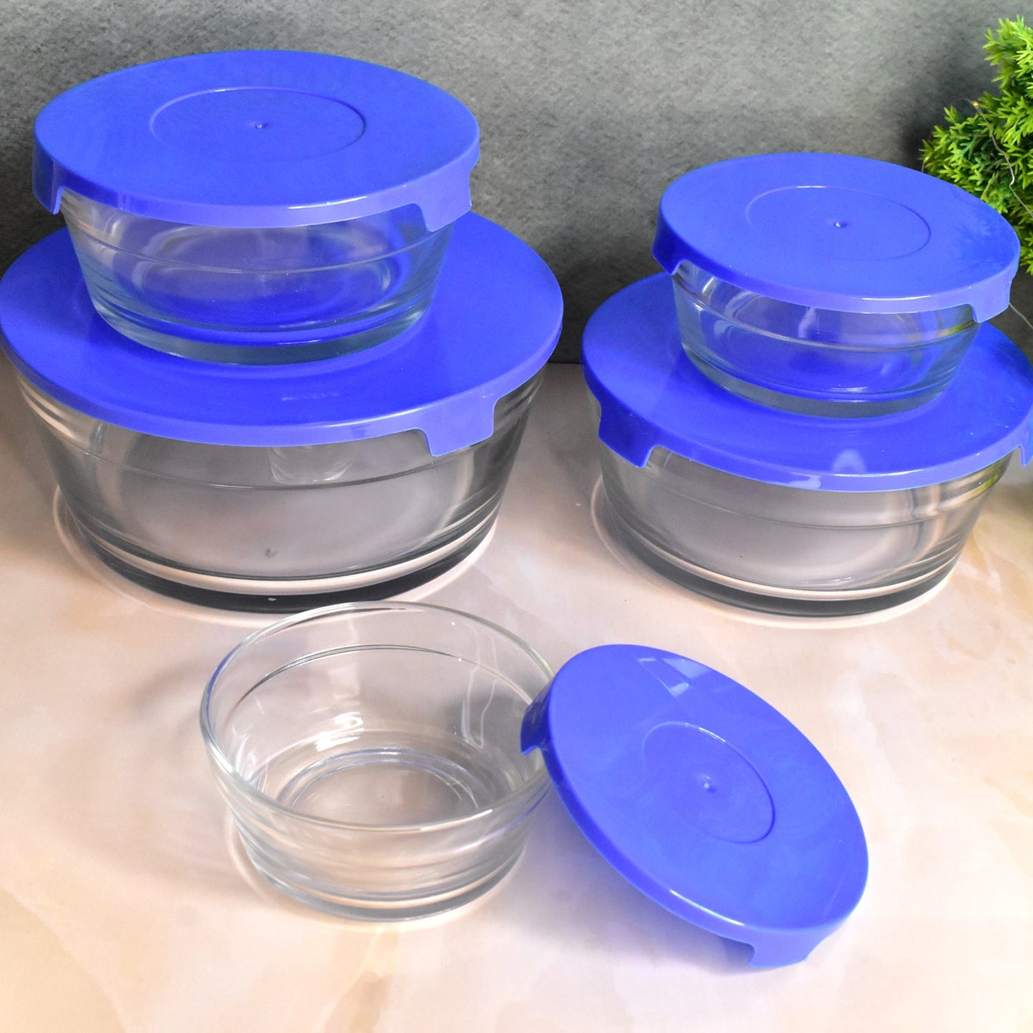 Glass bowls with lids used for mixing ingredients in a modern kitchen setting.