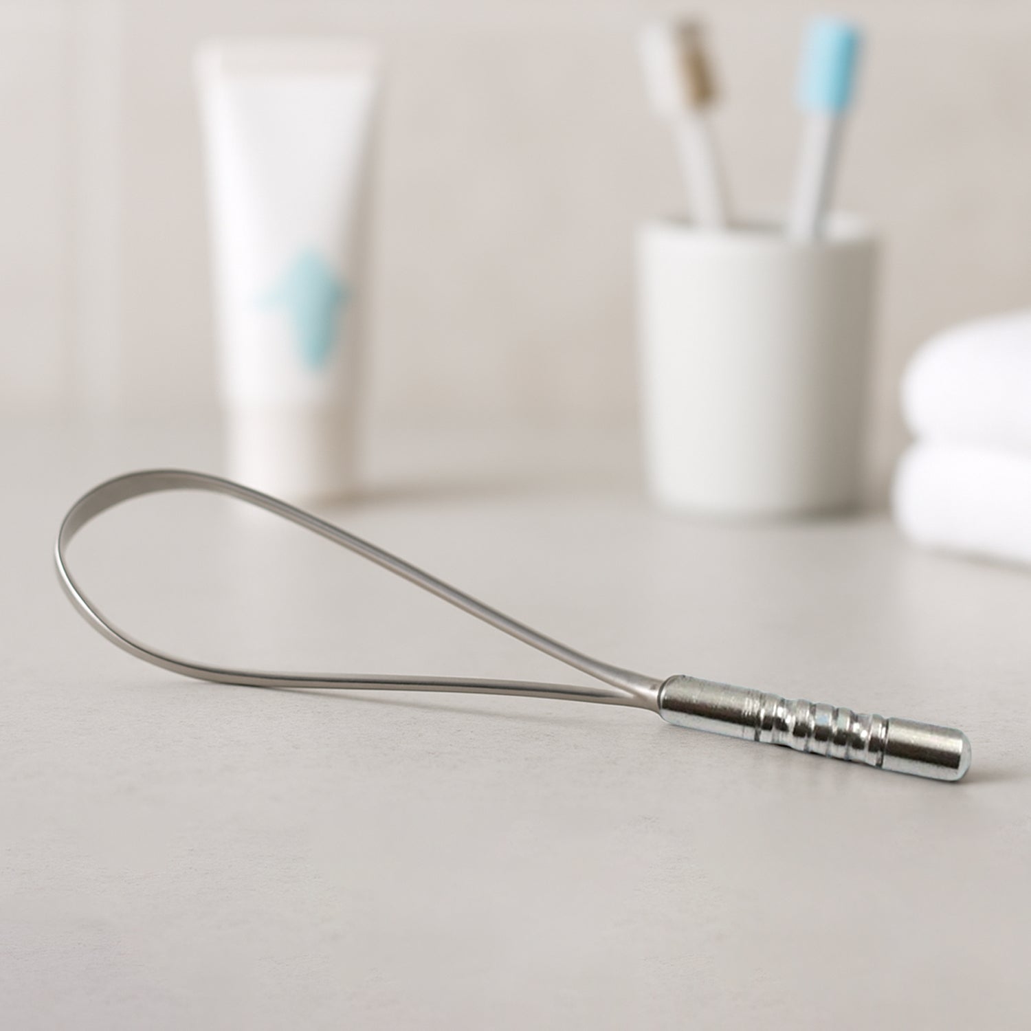 MintGuard Steel Tongue Cleaner displayed with its product packaging.