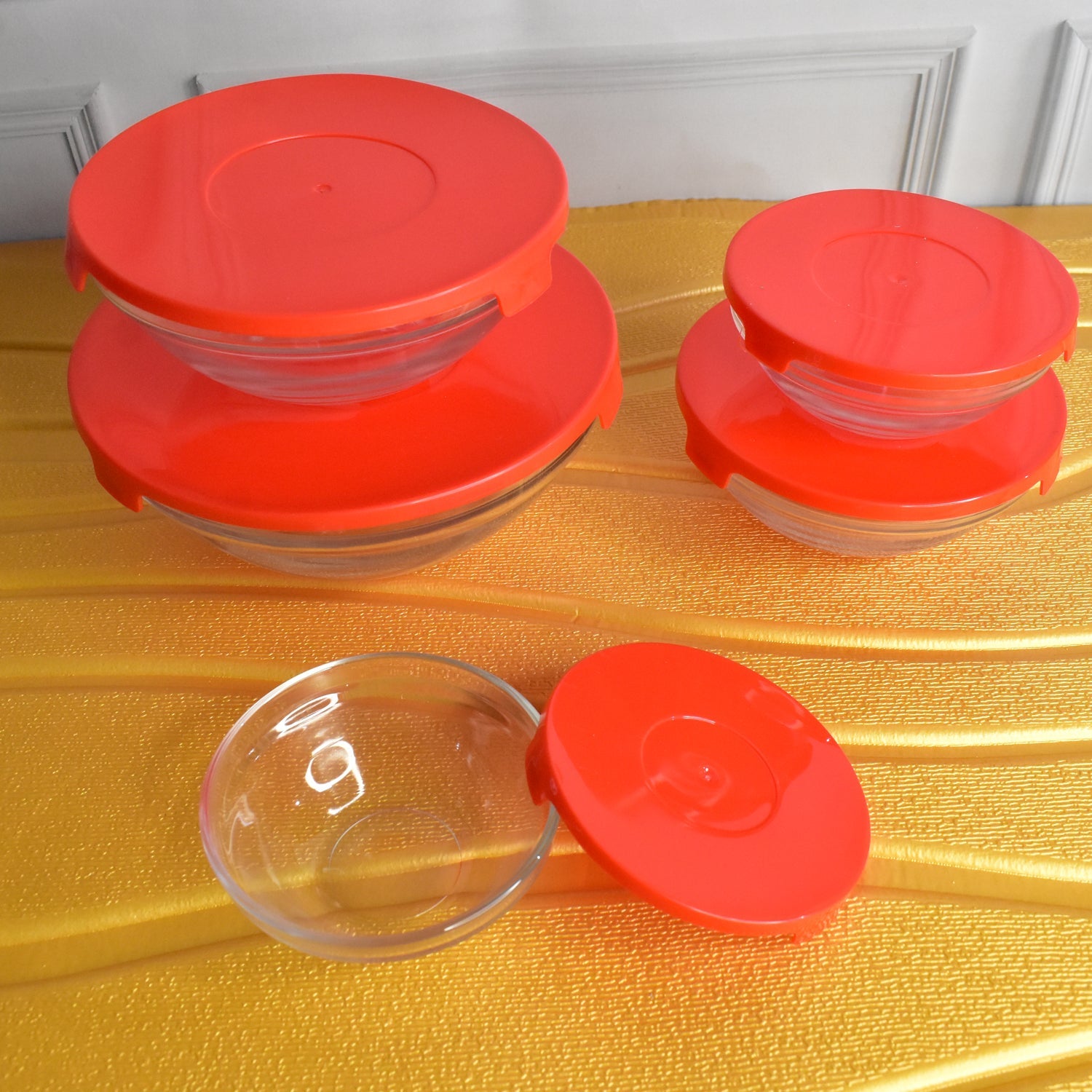 Various sizes of Organivo glass mixing bowls with red lids displayed, suitable for different kitchen needs.