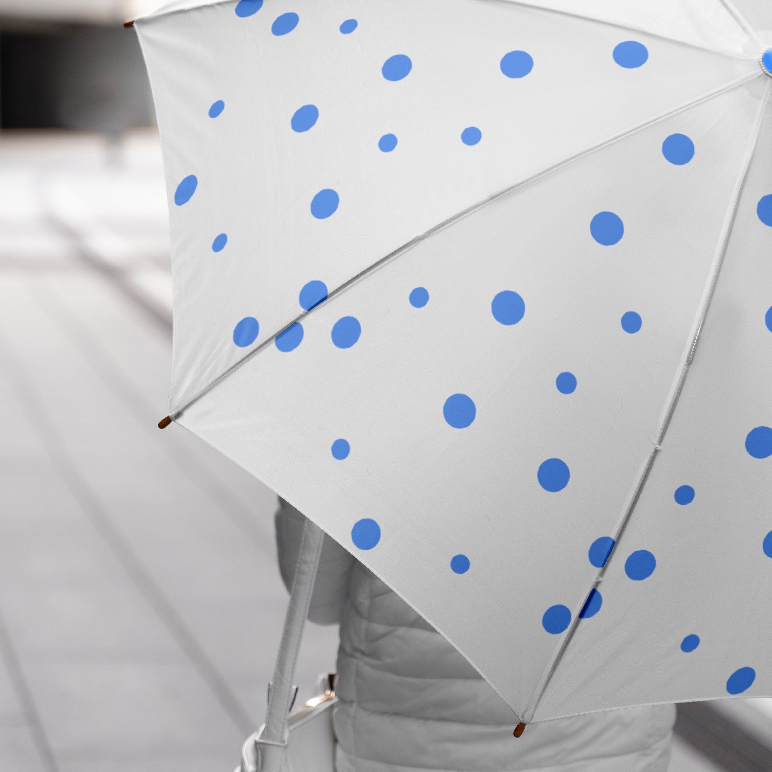 Opened dot printed umbrella showcasing its wide coverage against rain.