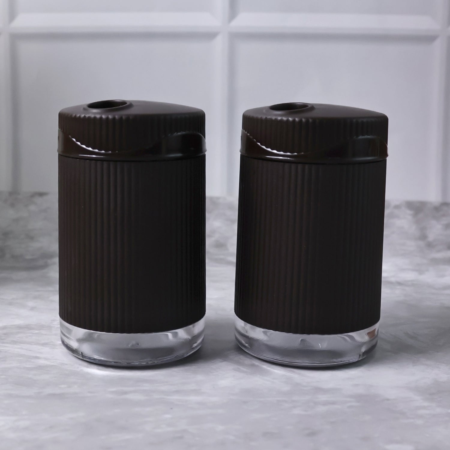 Salt and pepper dispenser set featuring transparent bases for easy spice monitoring