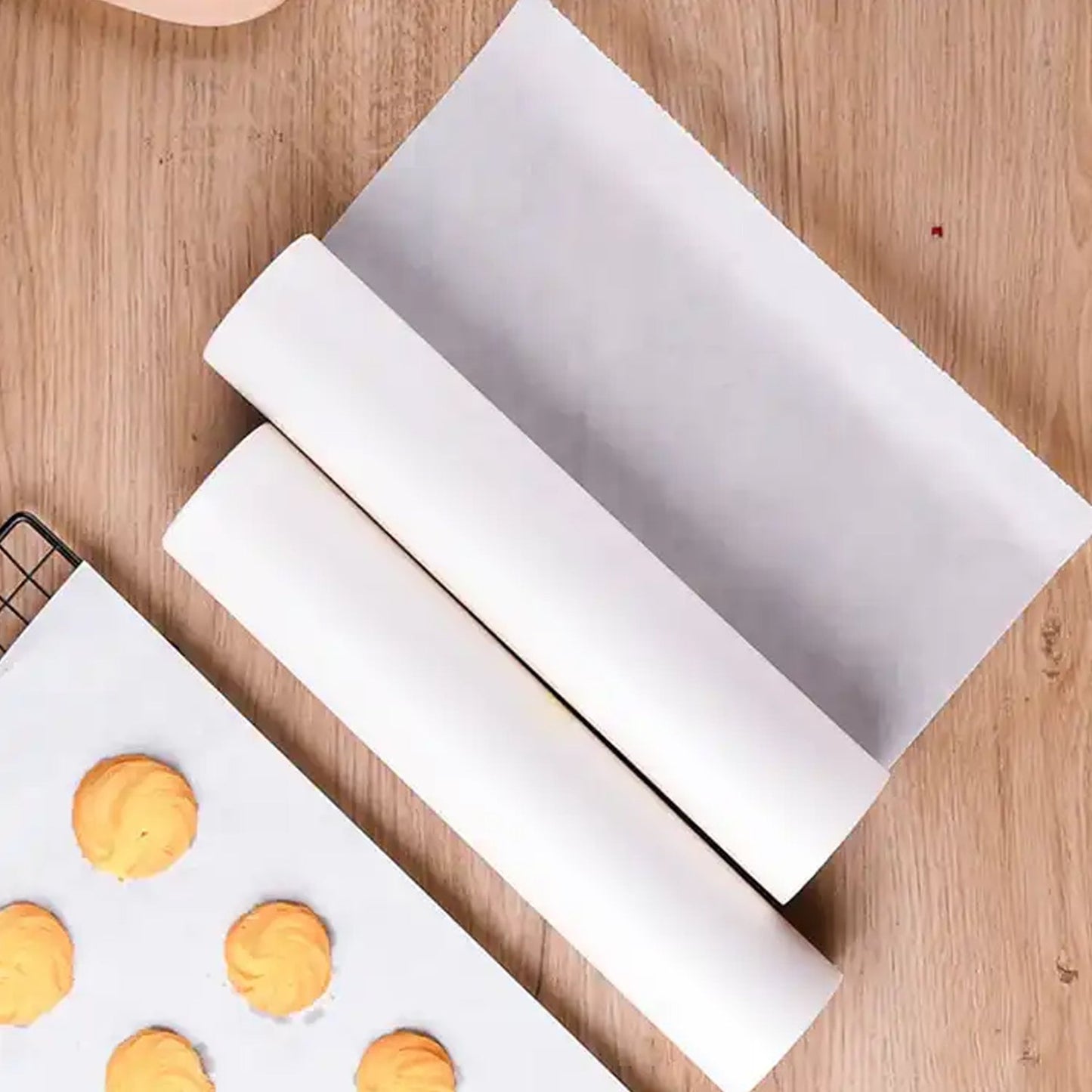 Roll of non-stick parchment paper for baking and cooking on a wooden surface.