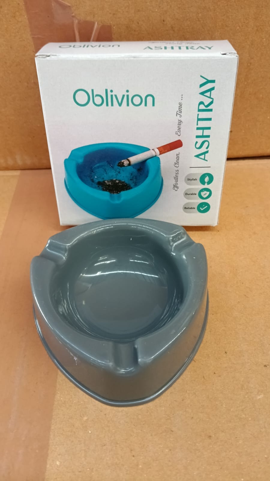 Durable grey plastic ashtray placed on table, ideal for home or office