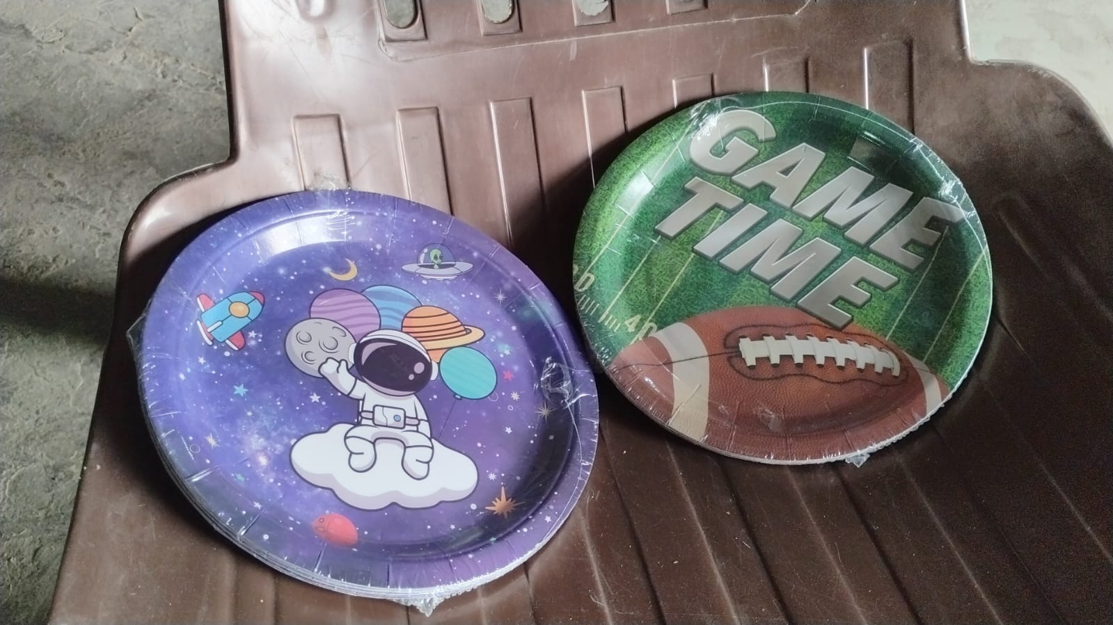 Neatly stacked disposable paper plates with festive birthday designs.