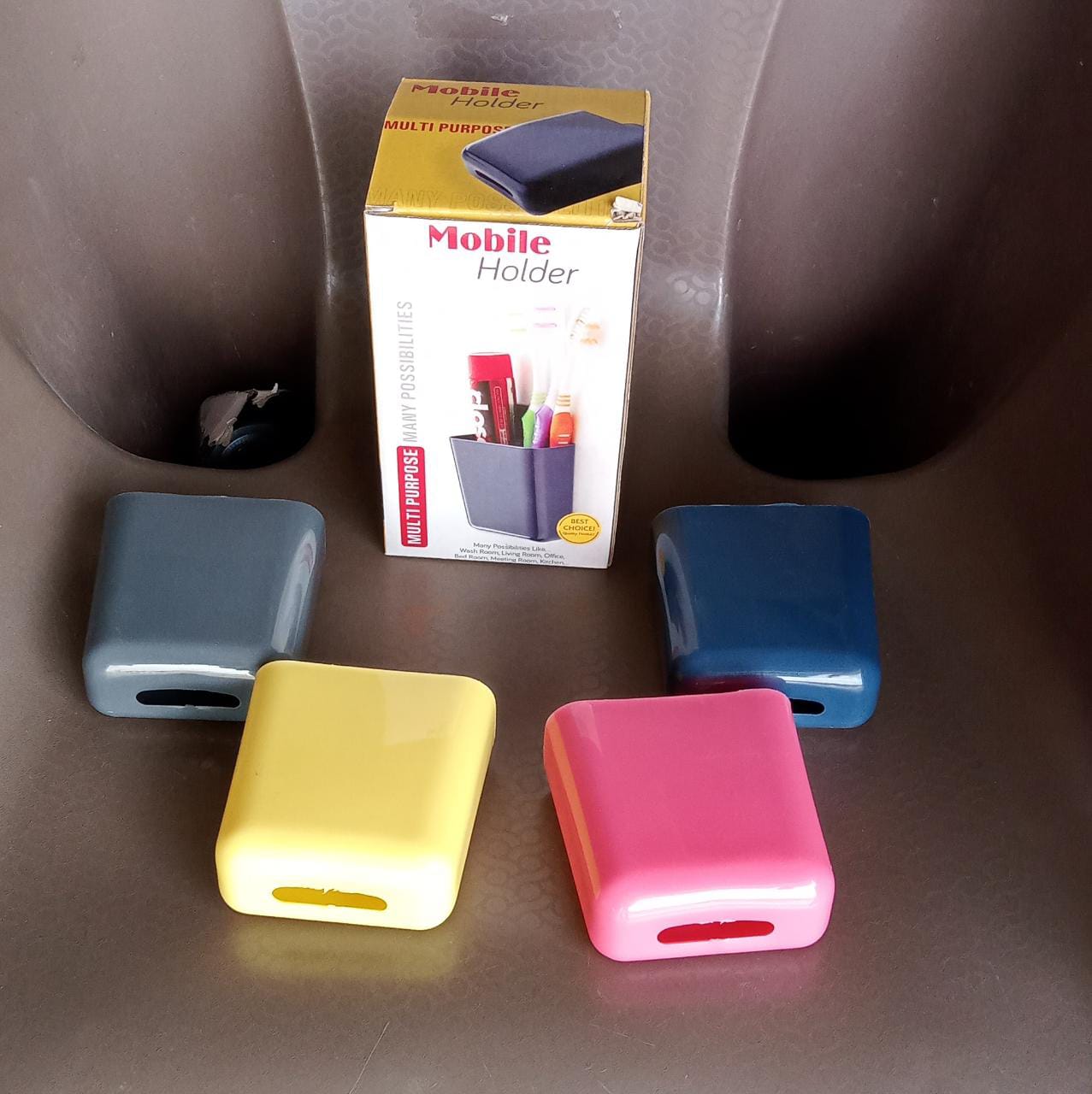 A white wall mounted storage case with a mobile phone and charging cable inserted.